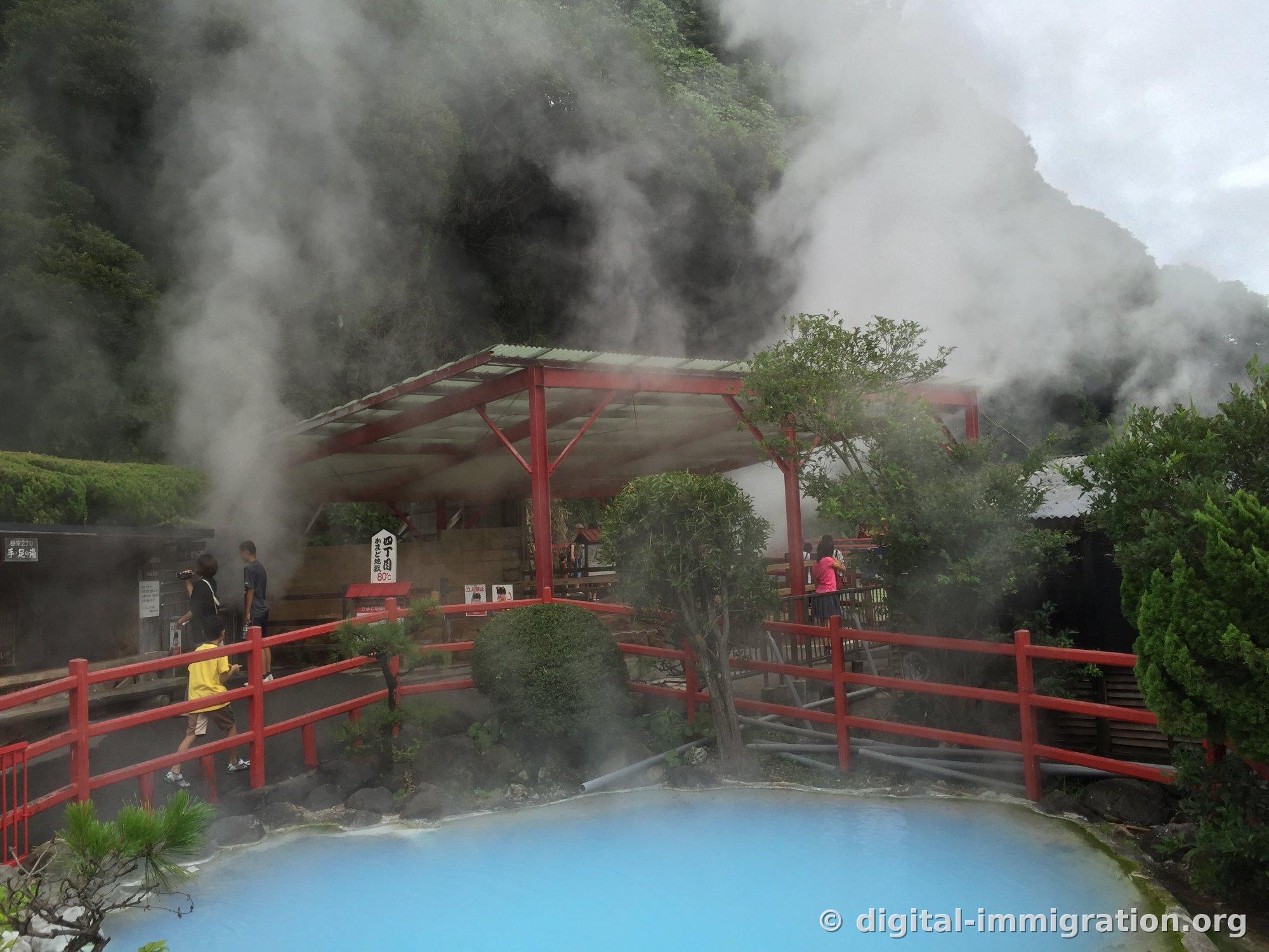 Une explosion de vapeur blanche s'échappant du même bassin bleu ciel, recouvrant complètement la montagne et le pavillon à l'arrière-plan