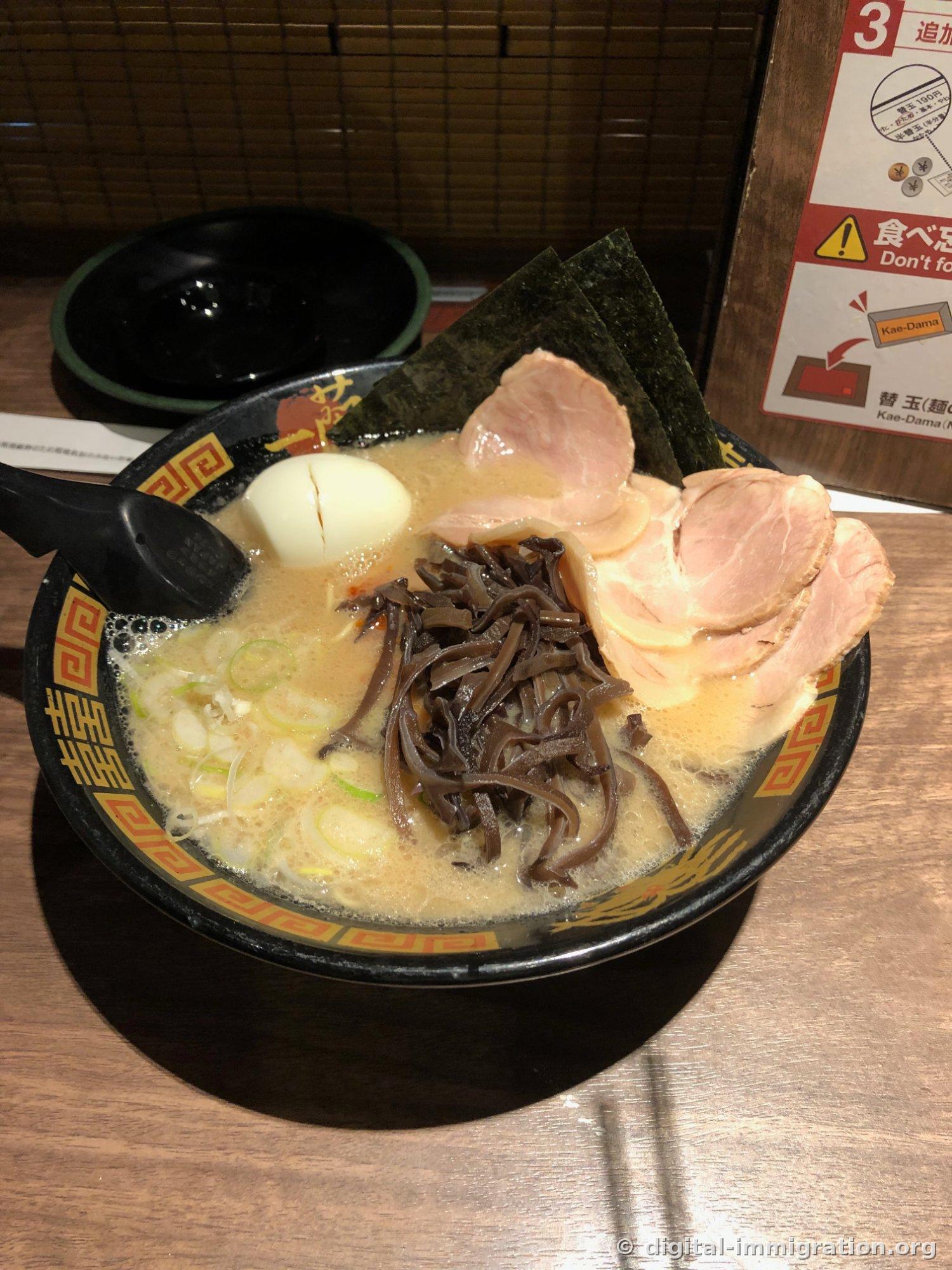 Un bol de ramen Ichiran complètement garni avec du char siu, du kikurage, un œuf fendu en deux et deux feuilles de nori