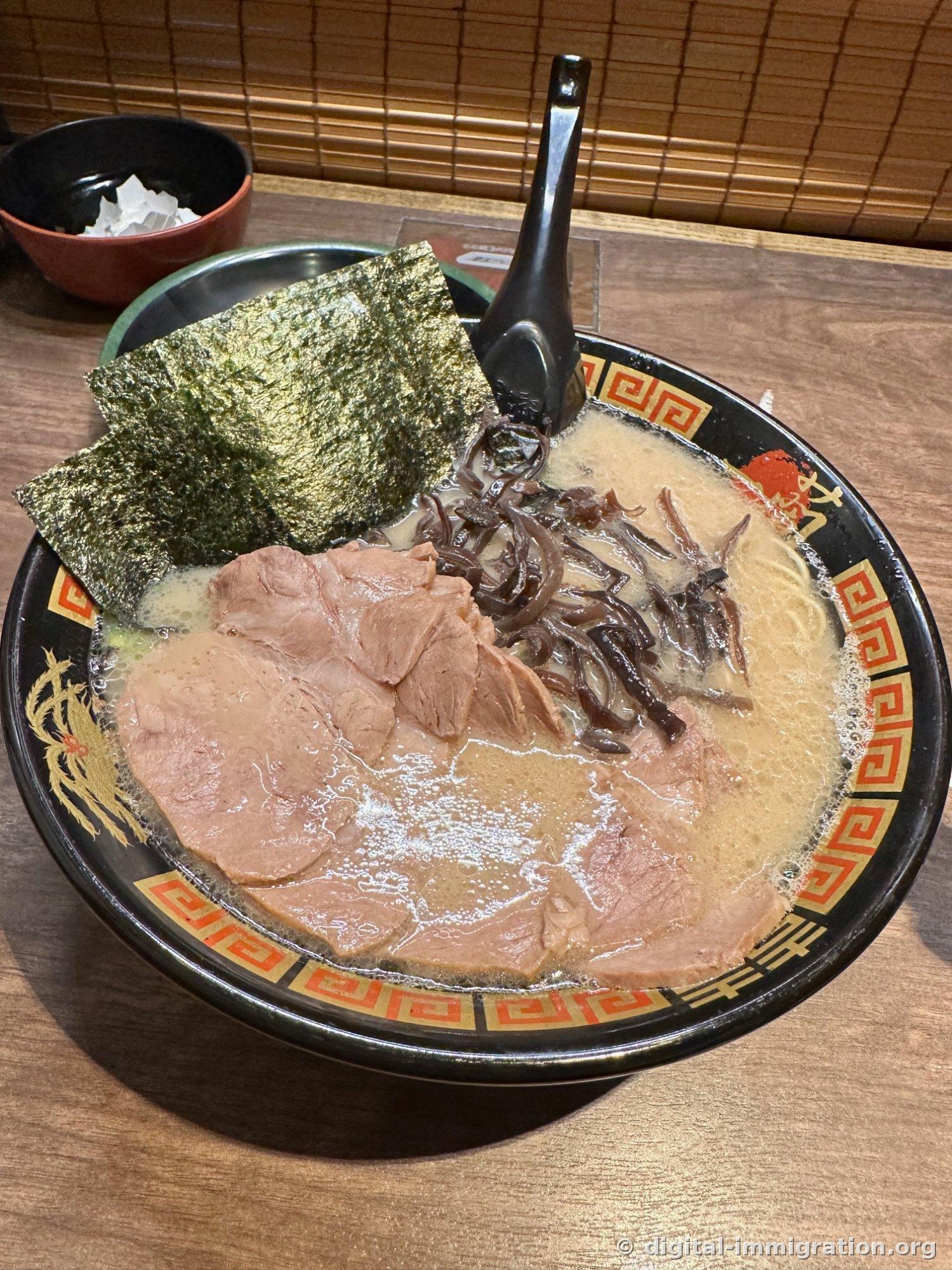 Photo d'en haut du ramen avec du char siu largement étalé et du kikurage et du nori dessus