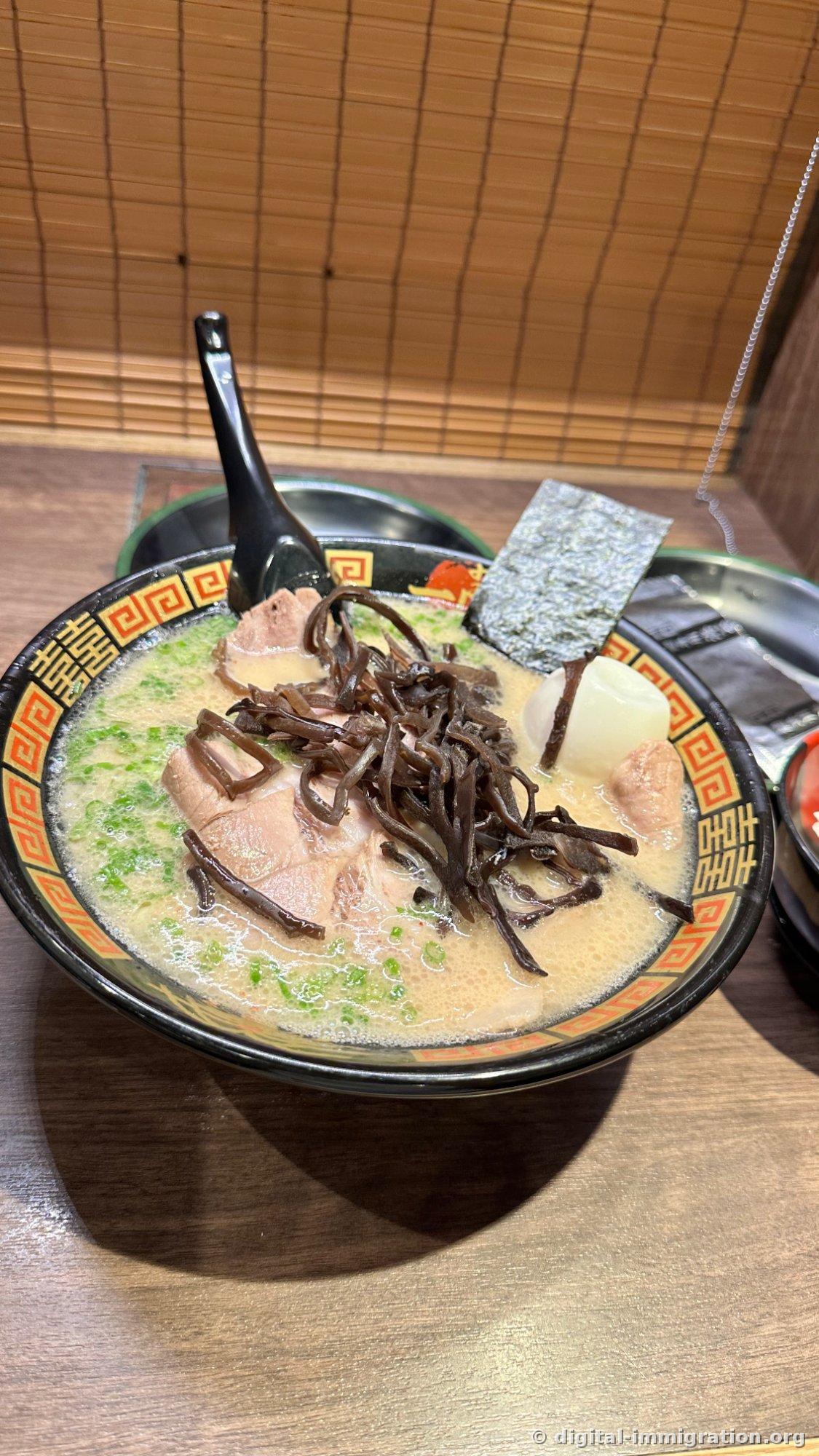 Un bol de ramen avec beaucoup de kikurage au centre et un œuf entier avec du nori dessus