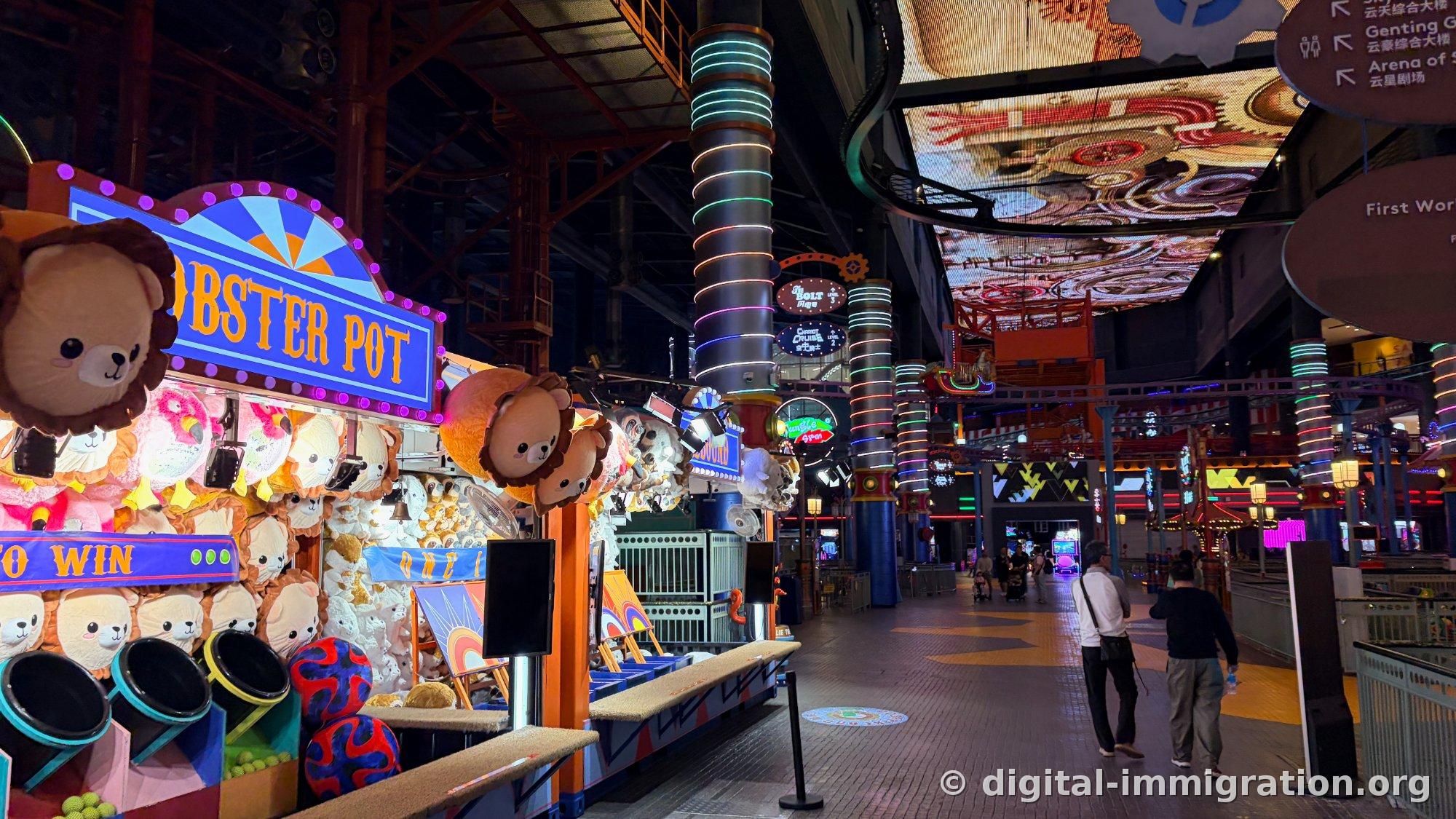 LOBSTER POT game booth full view and neon pillar-lined indoor street with directional signs for First World and Arena of Stars on upper right
