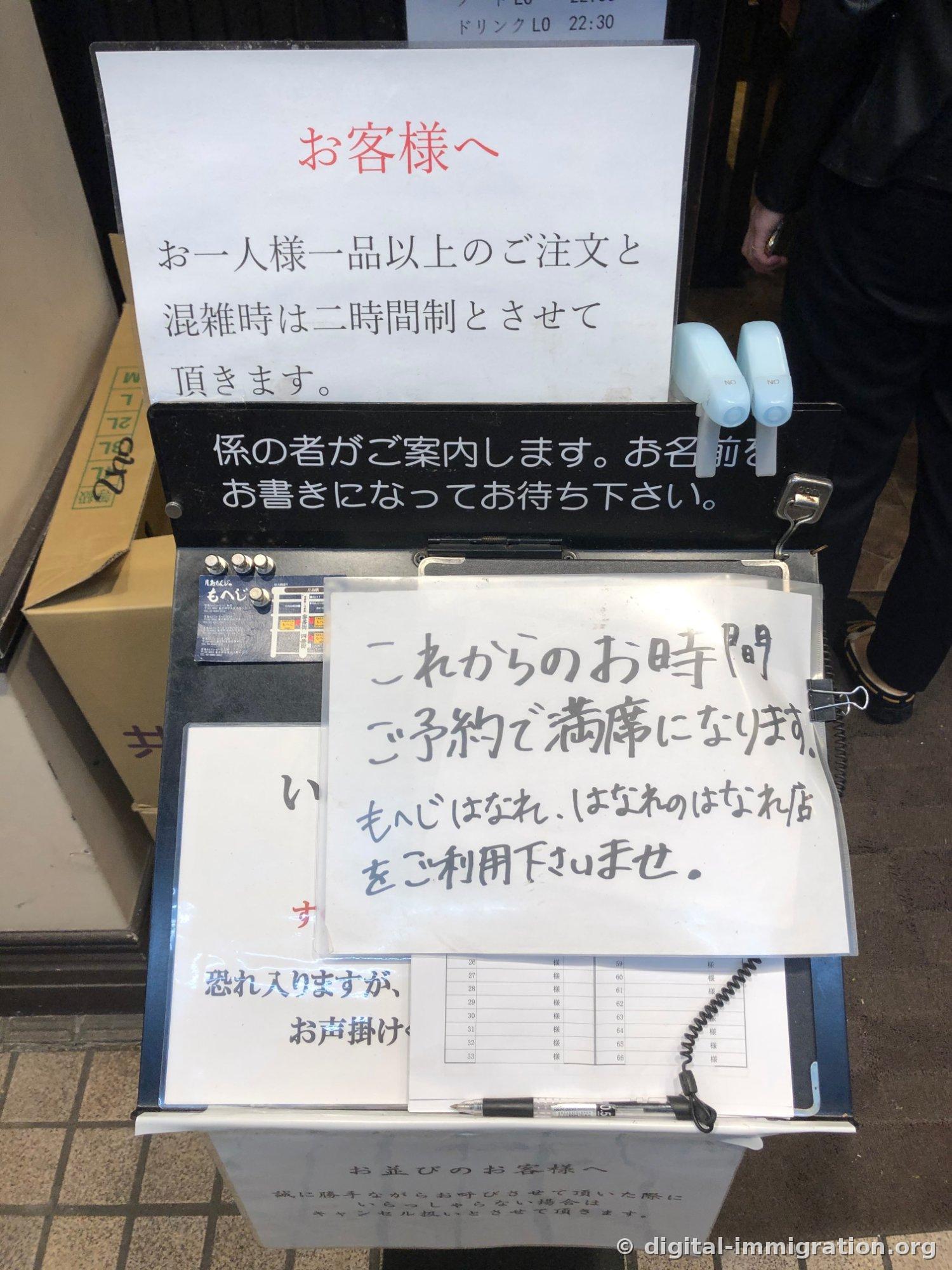 가게 앞 대기 접수대. 'お客様へ 1인 1품 이상 주문, 혼잡 시 2시간제' 안내문과 손글씨로 쓴 예약 만석 안내, 대기자 명단과 볼펜