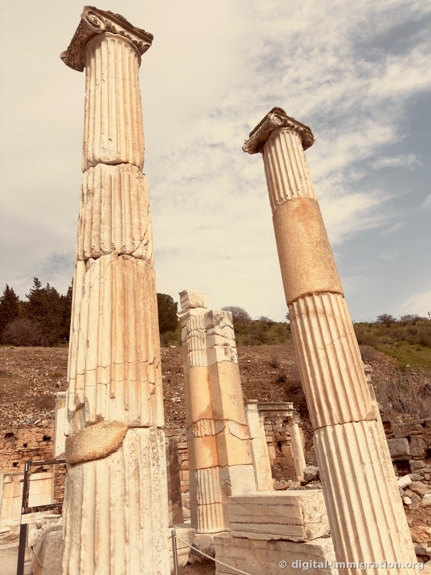 Two marble columns with Ionic capitals viewed from below, with stone of a different color wedged in the middle of the columns