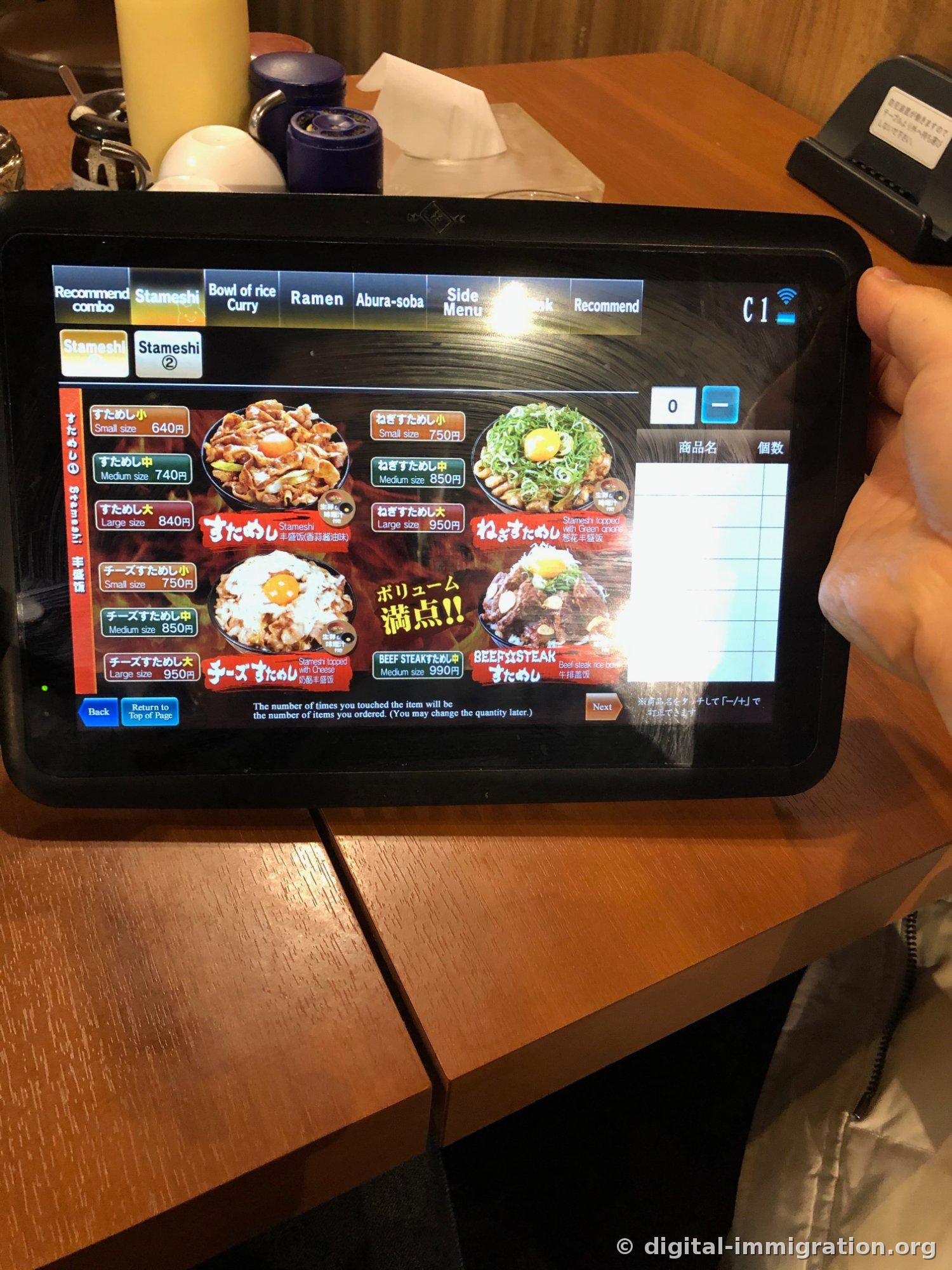 L'écran de la tablette de commande sur la table affiche les prix par taille pour le stameshi Petit/Moyen/Grand 640 yen/740 yen/840 yen avec des photos