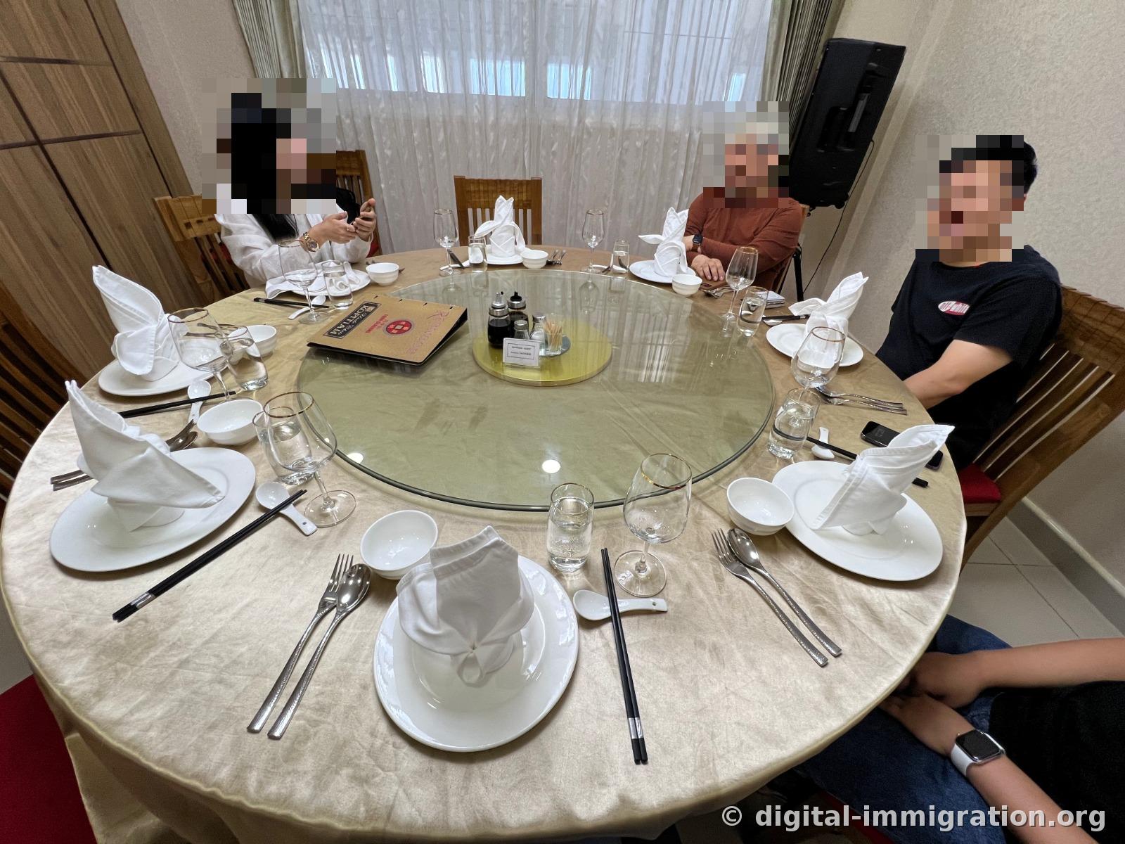 A set round table before the food arrives, with a glass lazy Susan in the center holding condiment bottles and menu card, and rabbit-shaped napkins and utensils placed at each seat