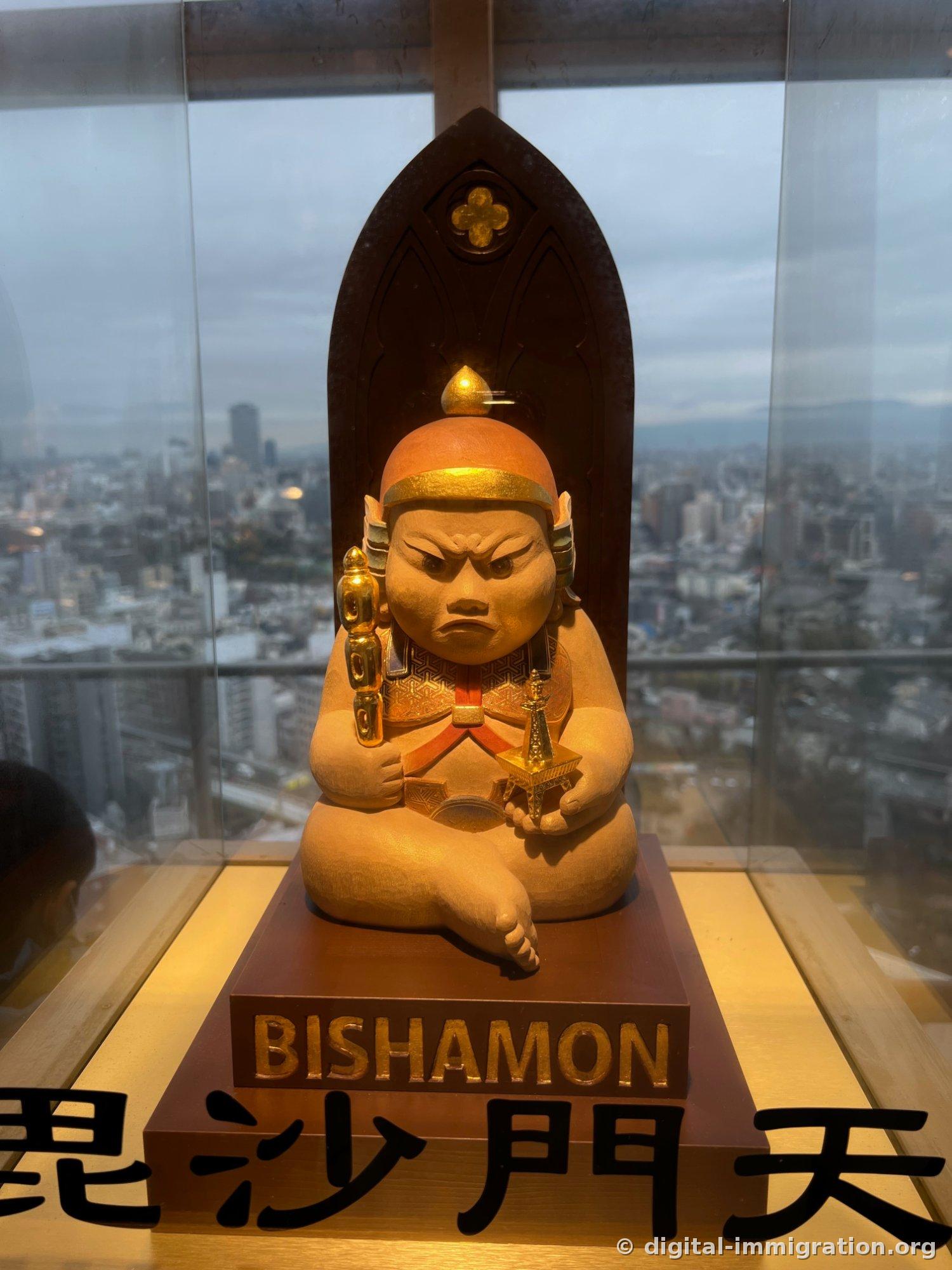 A wooden statue of Bishamonten wearing a helmet and frowning