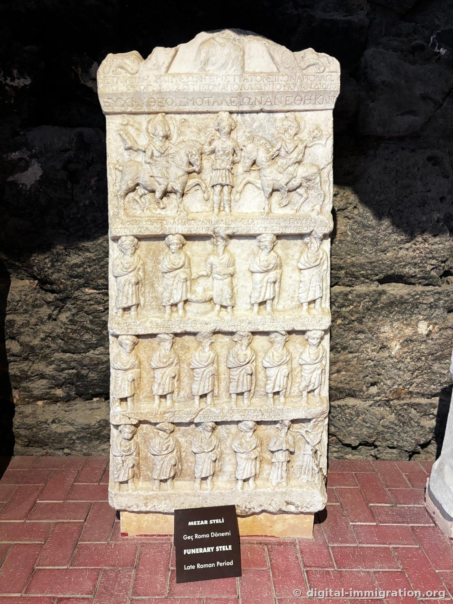 Marble funerary stele divided into four tiers with an equestrian figure and groups of people in relief, Greek inscriptions carved between each tier