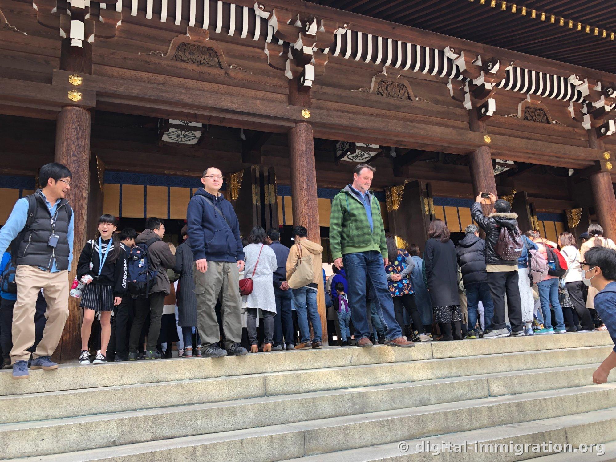 본전 계단 위에서 새전함을 향해 좌우로 길게 늘어서 참배하는 사람들