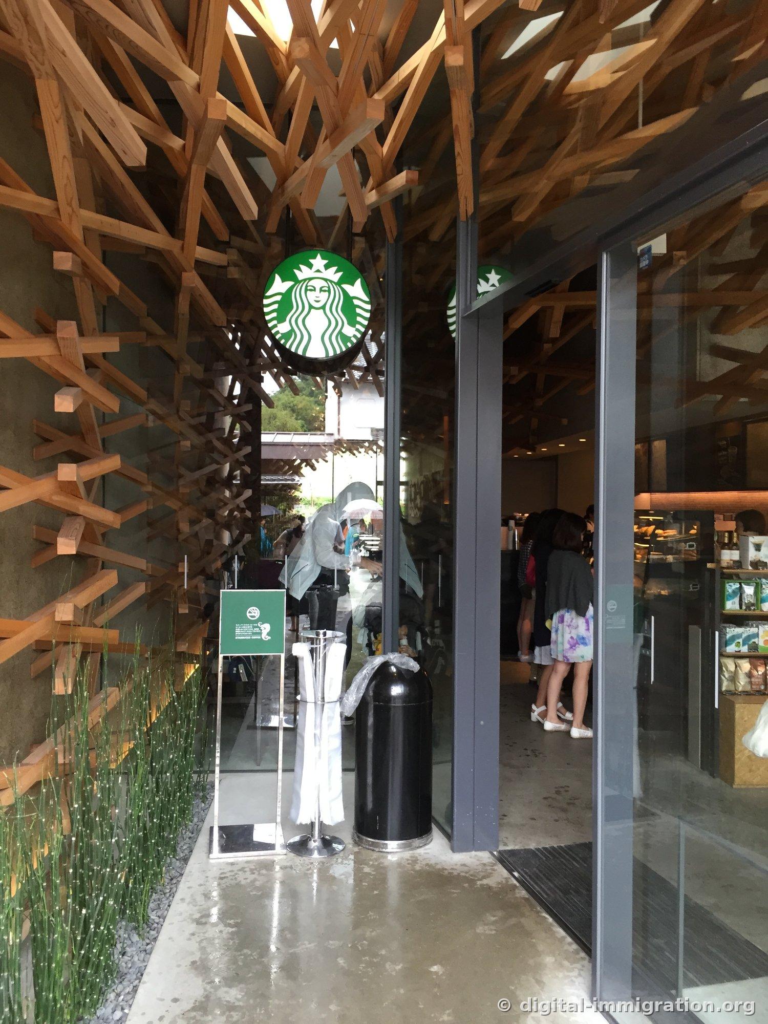 Inside the Starbucks entrance, wooden lattice converging from the ceiling and green Siren logo sign