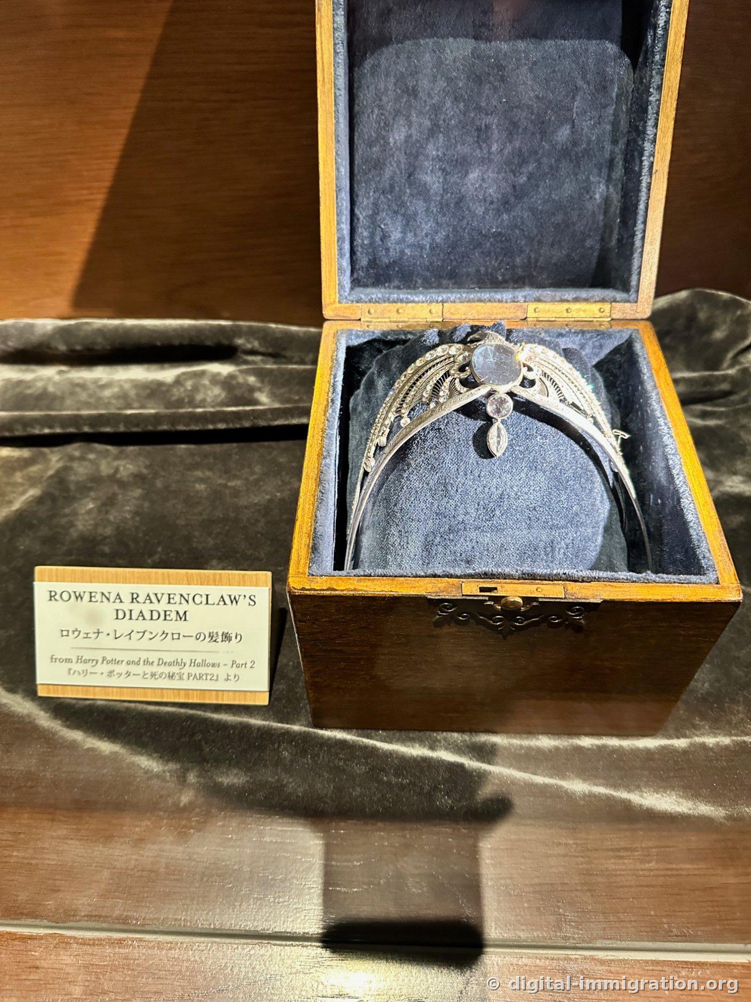 A silver crown with three transparent stones in an open wooden box lined with gray velvet, with the nameplate ROWENA RAVENCLAW'S DIADEM