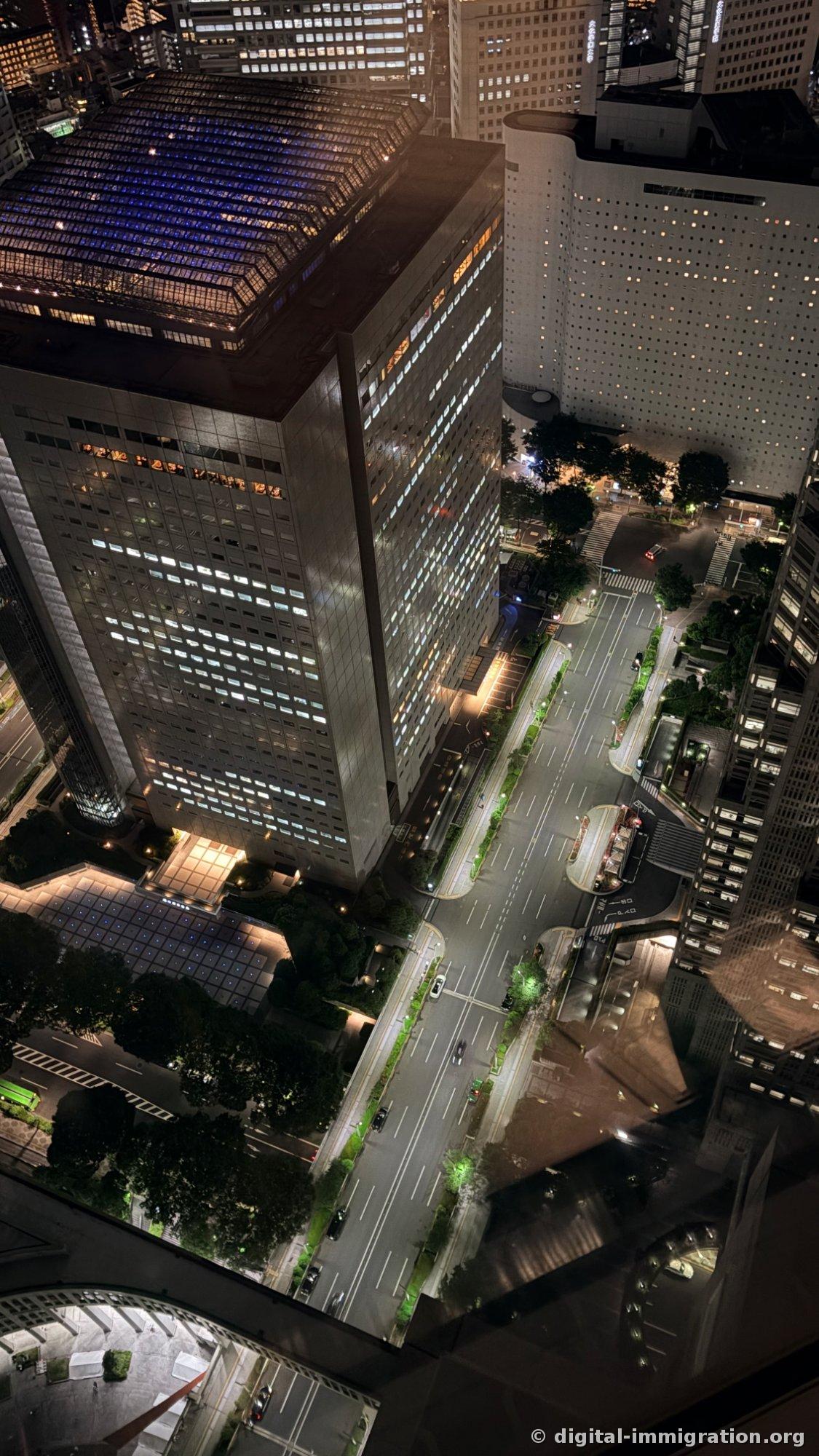 Vue verticale depuis la vitre de la salle d'observation sur l'avenue Nishi-Shinjuku avec la route déserte, les passages piétons et les toits des immeubles