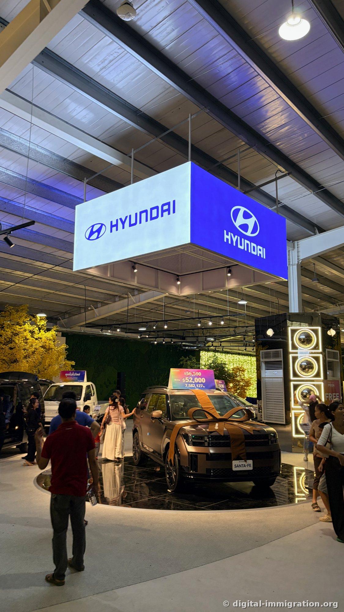 HYUNDAI sign above ribbon-wrapped Santa Fe displayed on rotating platform with $52,000 / 7,582,127 kip price tag