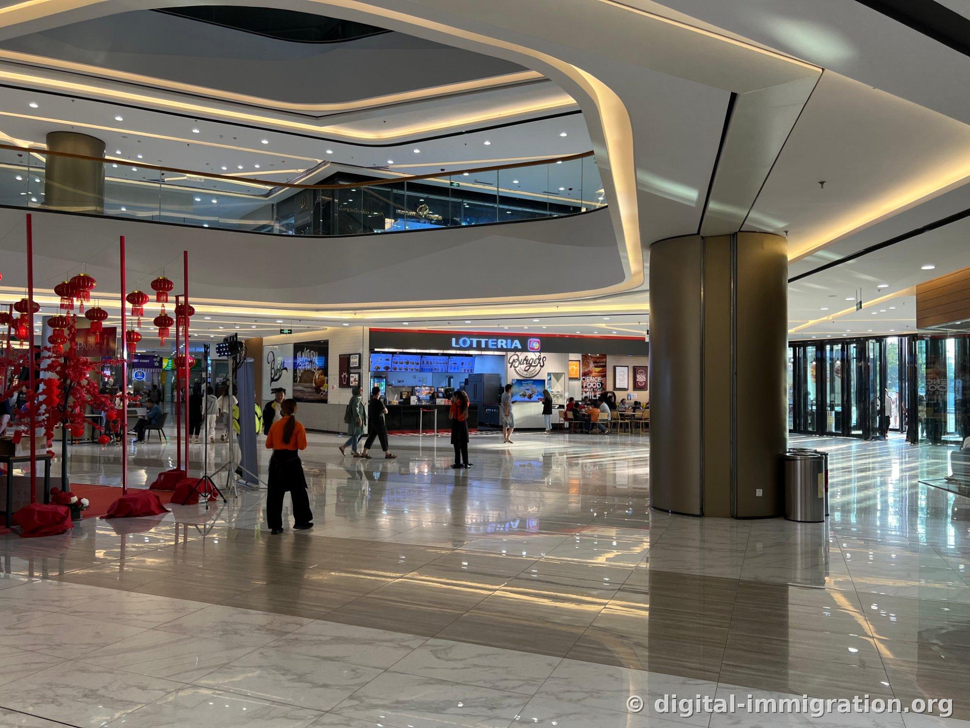 Intérieur du lobby du premier étage du Parkson Mall, avec le sol en marbre brillant et le magasin Lotteria au fond, décoration du Nouvel An chinois avec lanternes rouges et équipement de photo à gauche