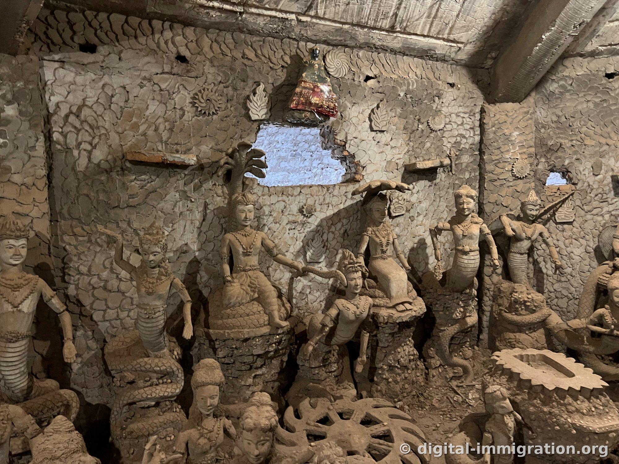 Plusieurs figures assises alignées sur le corps d'une naga face au mur couvert de motifs d'écailles de poisson, à l'étage intermédiaire du bâtiment citrouille