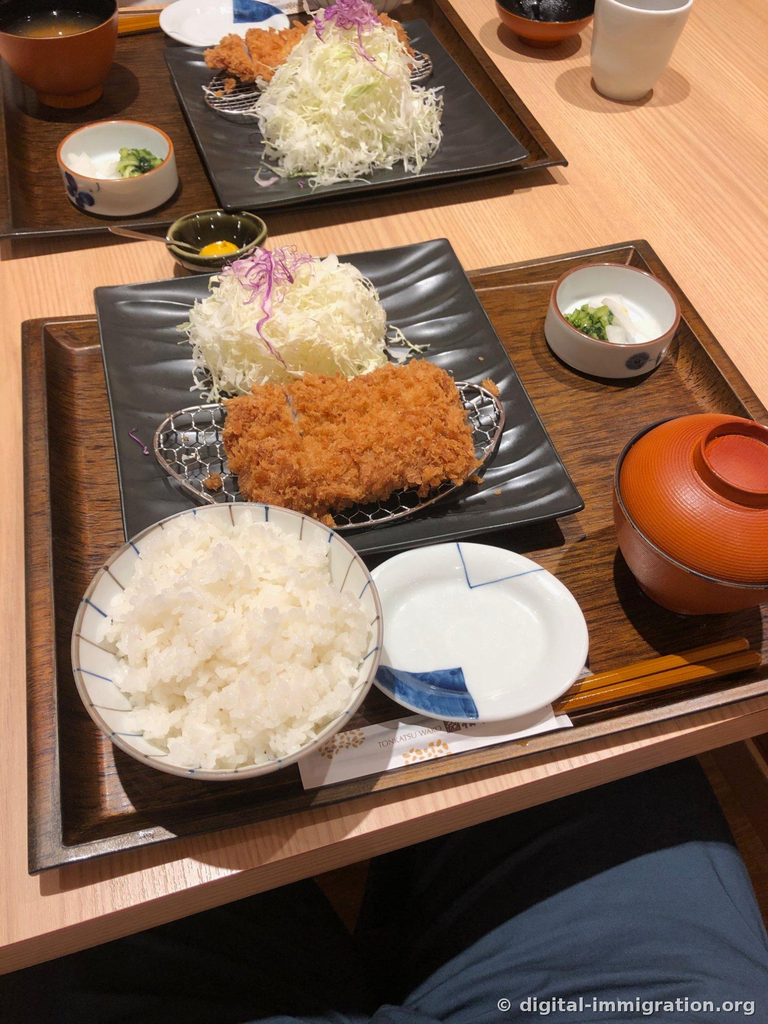 Plateau Ros Katsu complet sur un plateau en bois avec bol de riz blanc, bol de soupe miso rouge avec couvercle, petit plat de pickles, petit plat de moutarde, et petit plat blanc pour la sauce