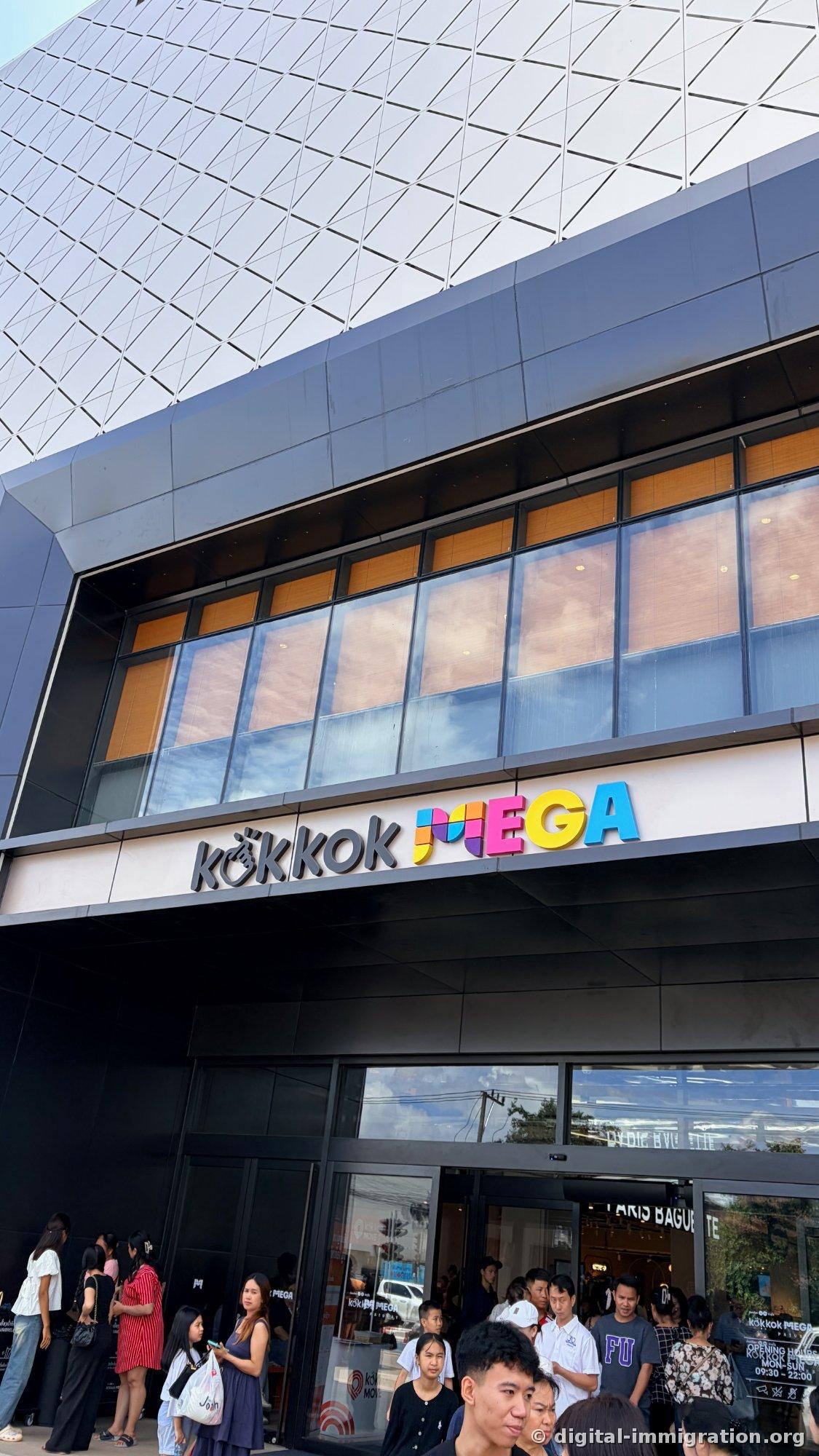 Main entrance with 'kōkkok MEGA' colored sign and local visitors gathered below