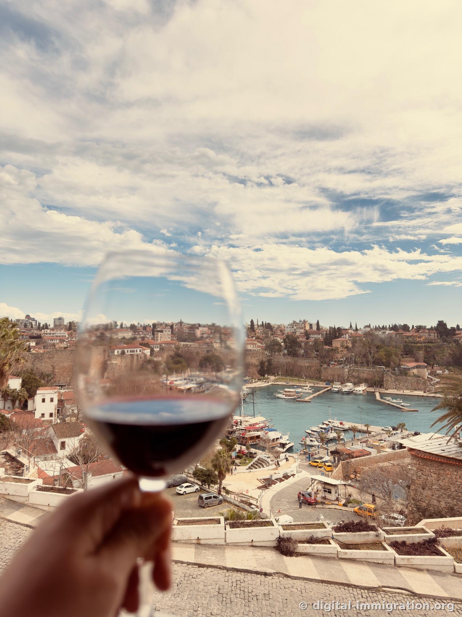 The harbor and old town visible through a red wine glass in hand