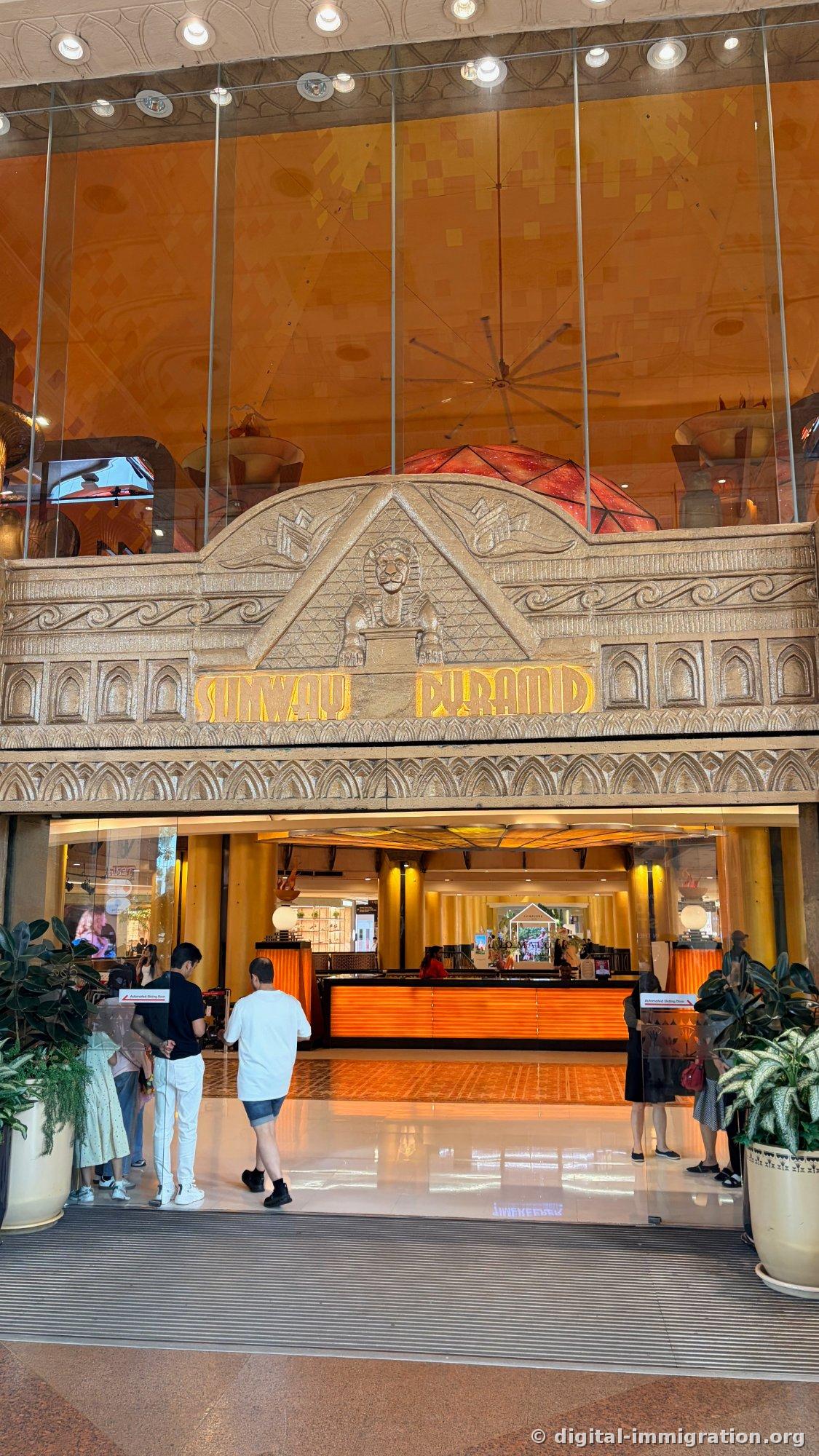带有斯芬克斯和金字塔浮雕装饰的 Sunway Pyramid 正门玻璃门和其内侧的橙色指示台
