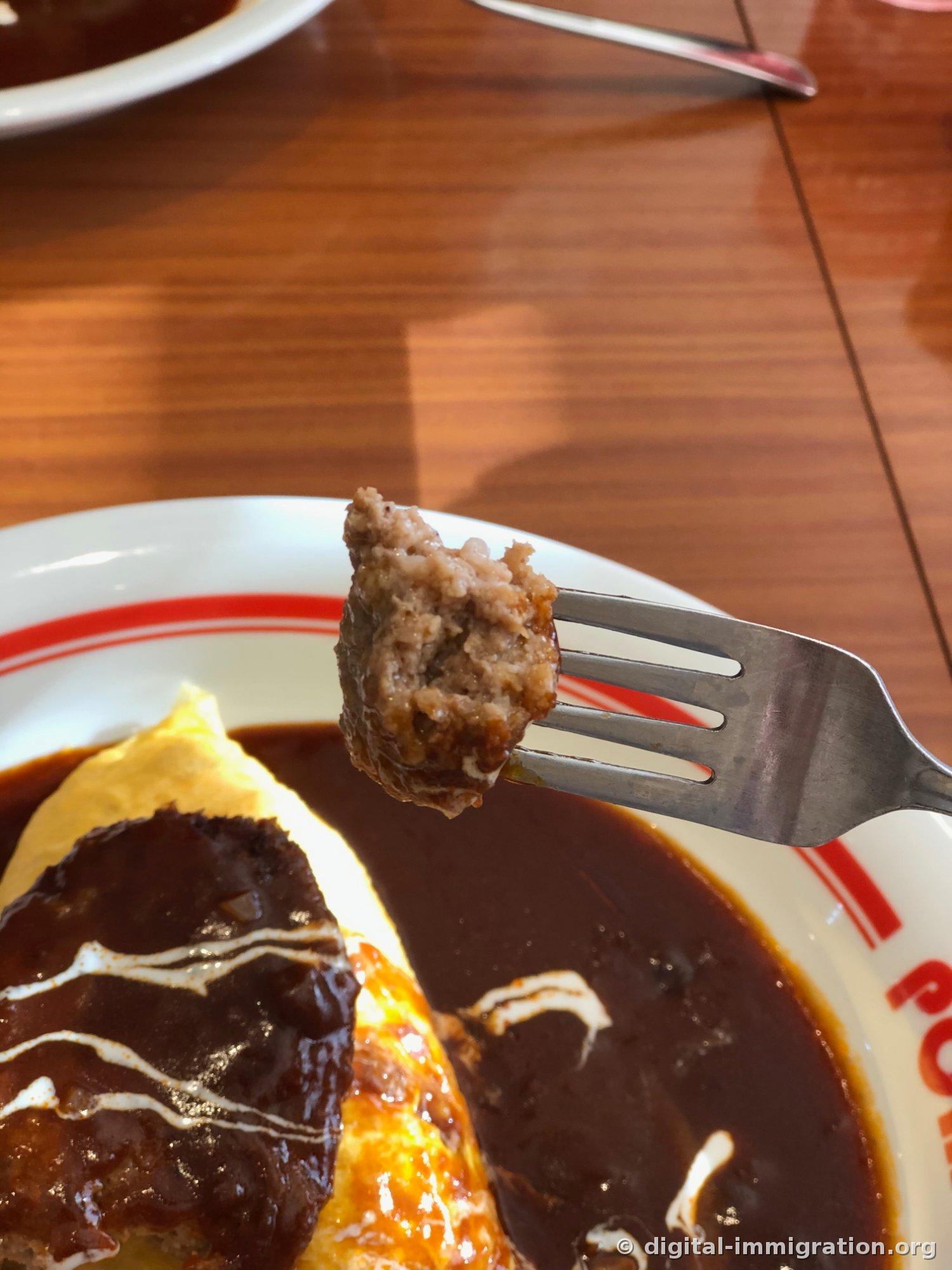 Un morceau de steak haché soulevé par une fourchette. La section transversale montre les fibres de viande hachée