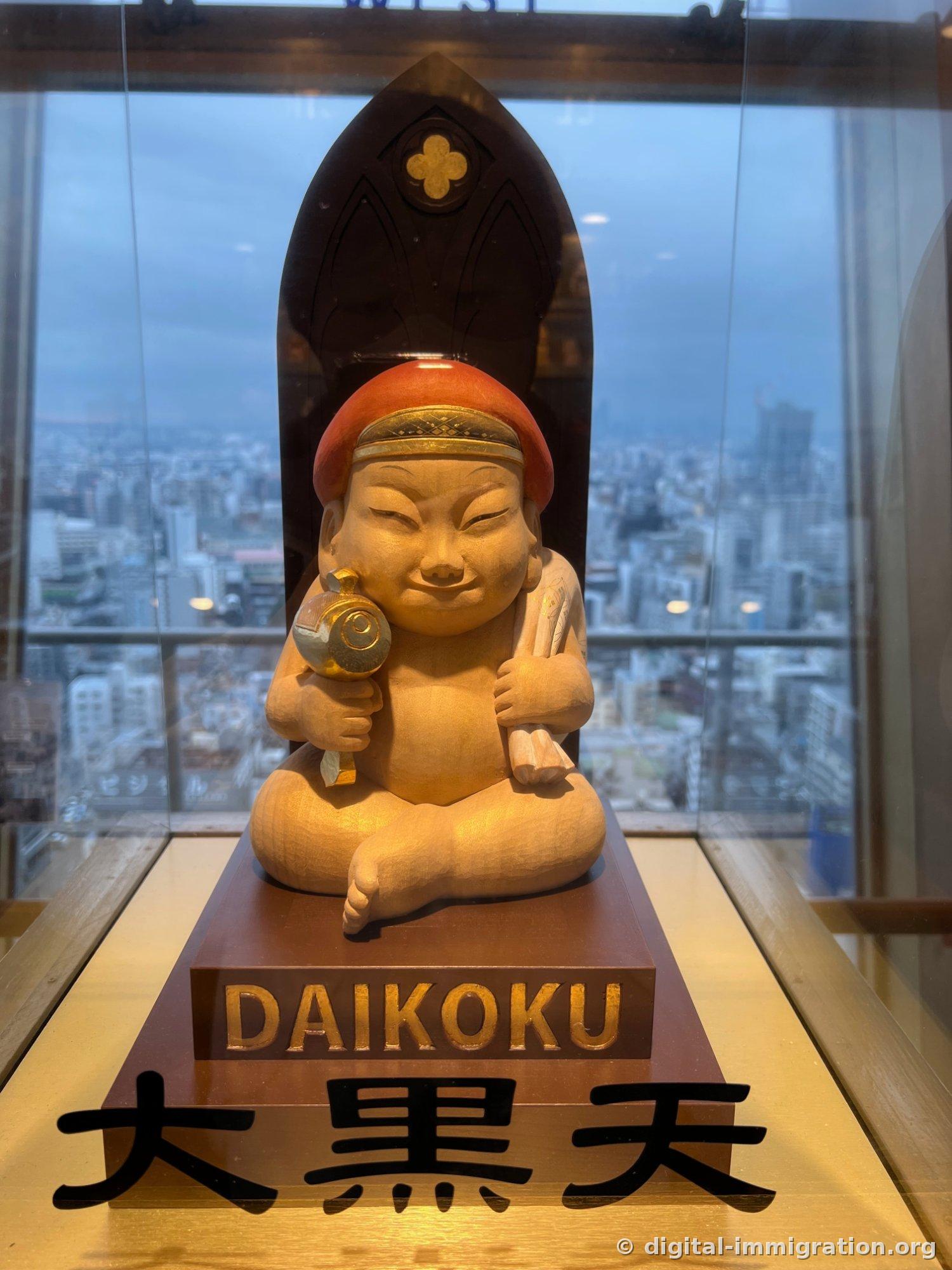 A wooden statue of Daikokuten wearing a red hood and holding a mallet