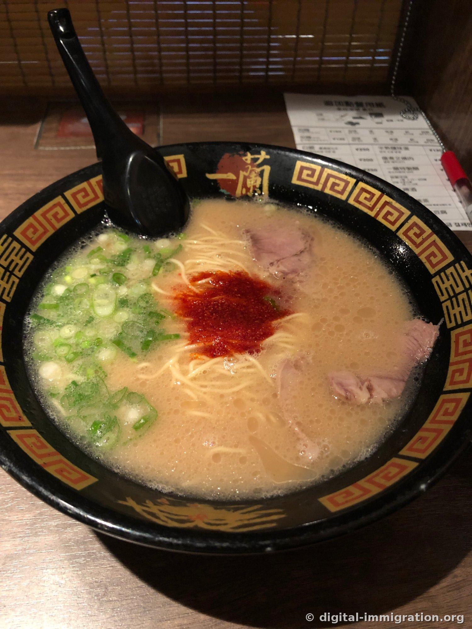 Un bol de ramen tonkotsu de base d'Ichiran garni d'oignons verts et de sauce spéciale rouge, avec du char siu