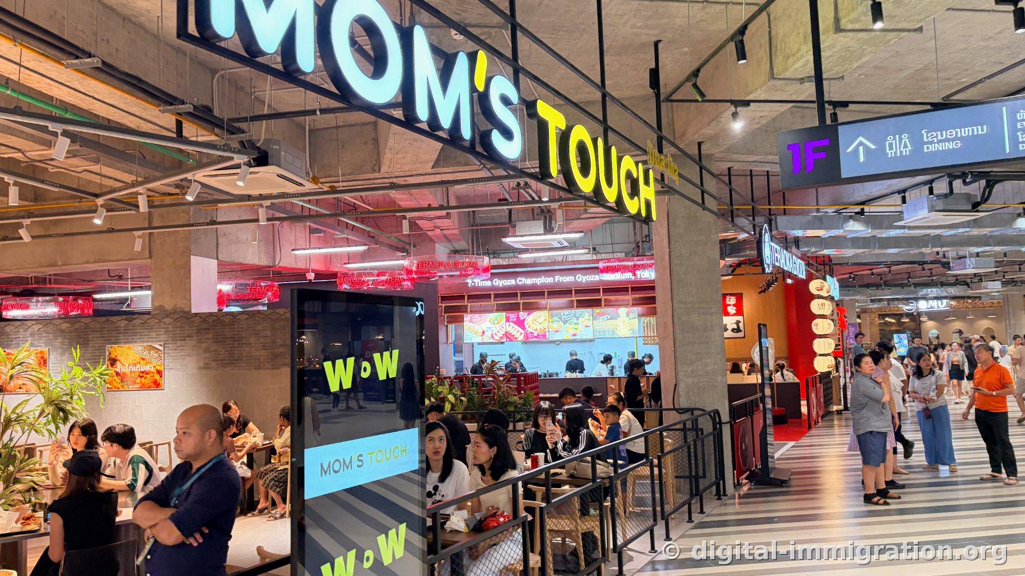 MOM'S TOUCH store on ground floor dining area with red neon TERAOKA GYOZA sign next to it, 1F DINING sign above right