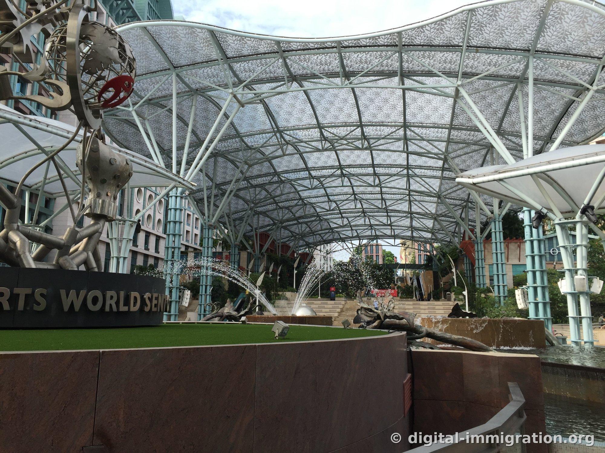RESORTS WORLD SENTOSA sign and fountains spraying under a curved canopy with leaf patterns