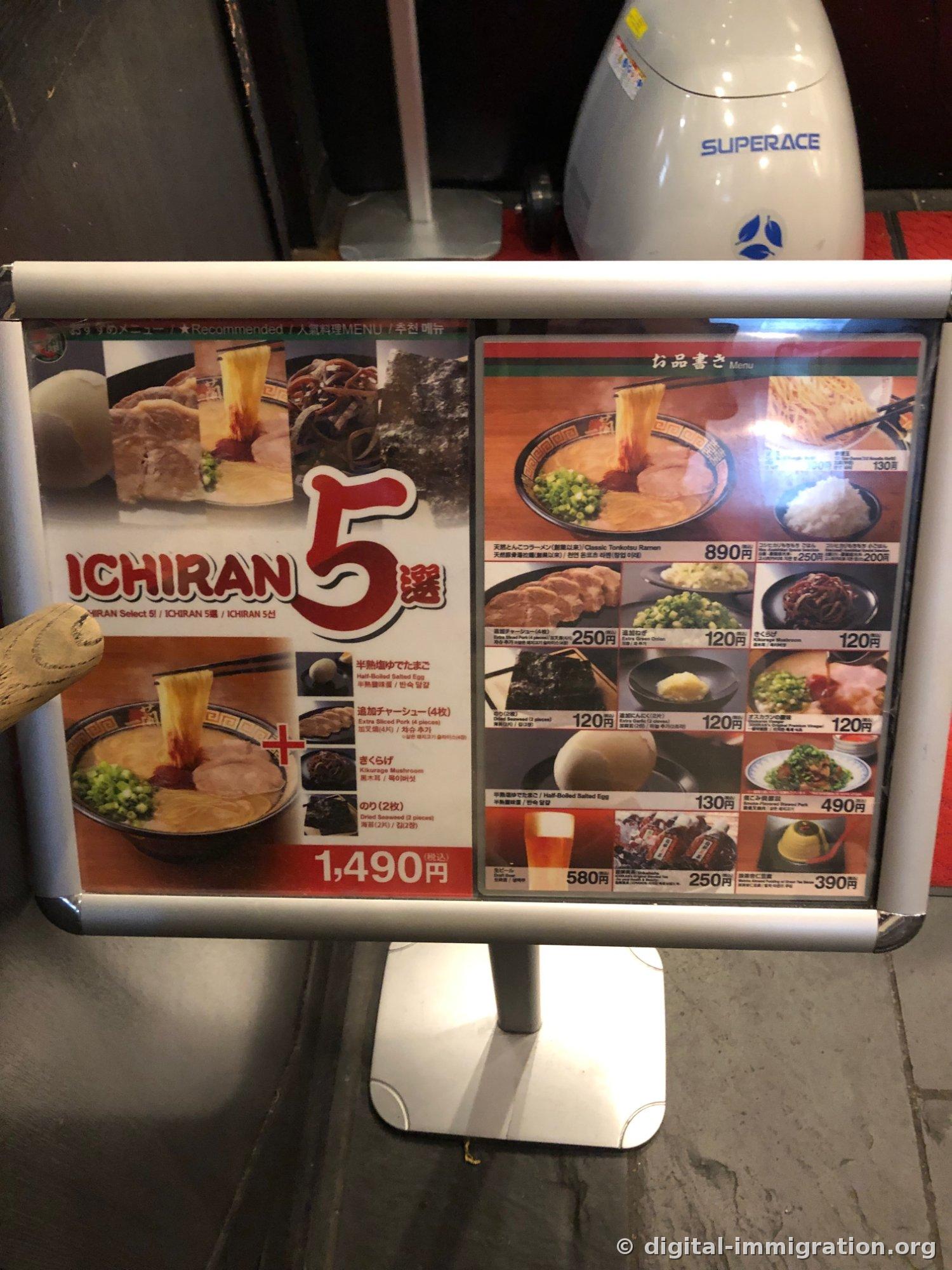 Photo d'un présentoir de menu affichant l'ensemble 5 signatures Ichiran à 1 490 yens et les prix à l'unité, avec l'étiquetage en coréen aussi