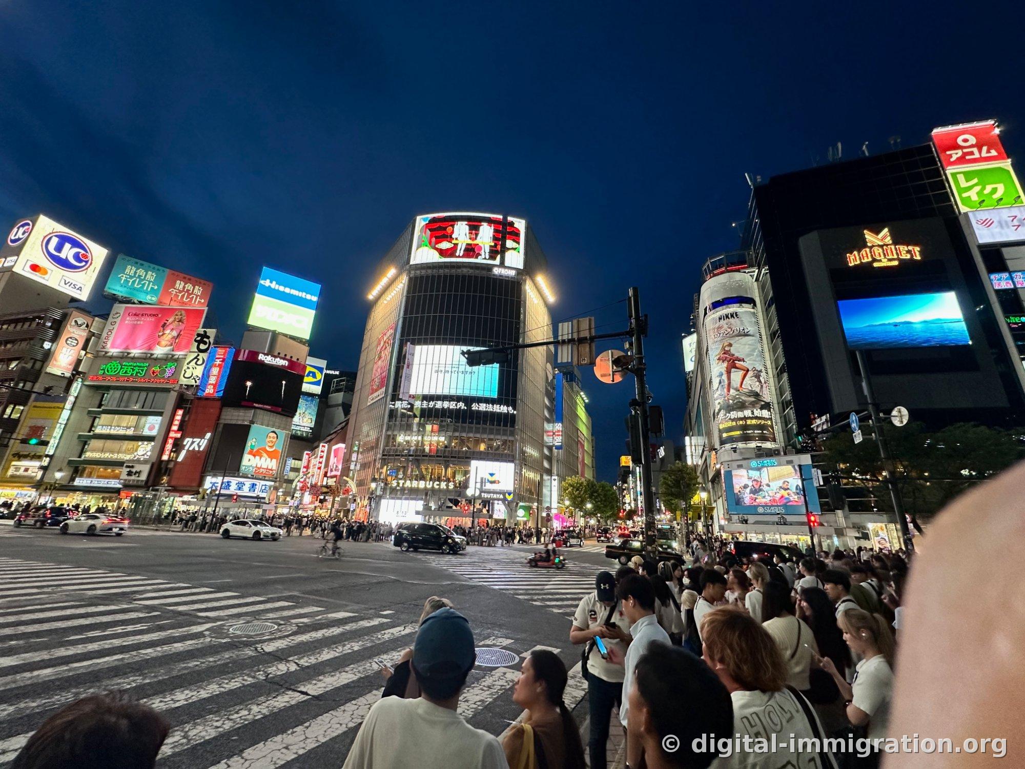 同じ交差点を少し低い角度から撮った夜の写真、UCカードと久光製薬、龍角散の広告板が見える