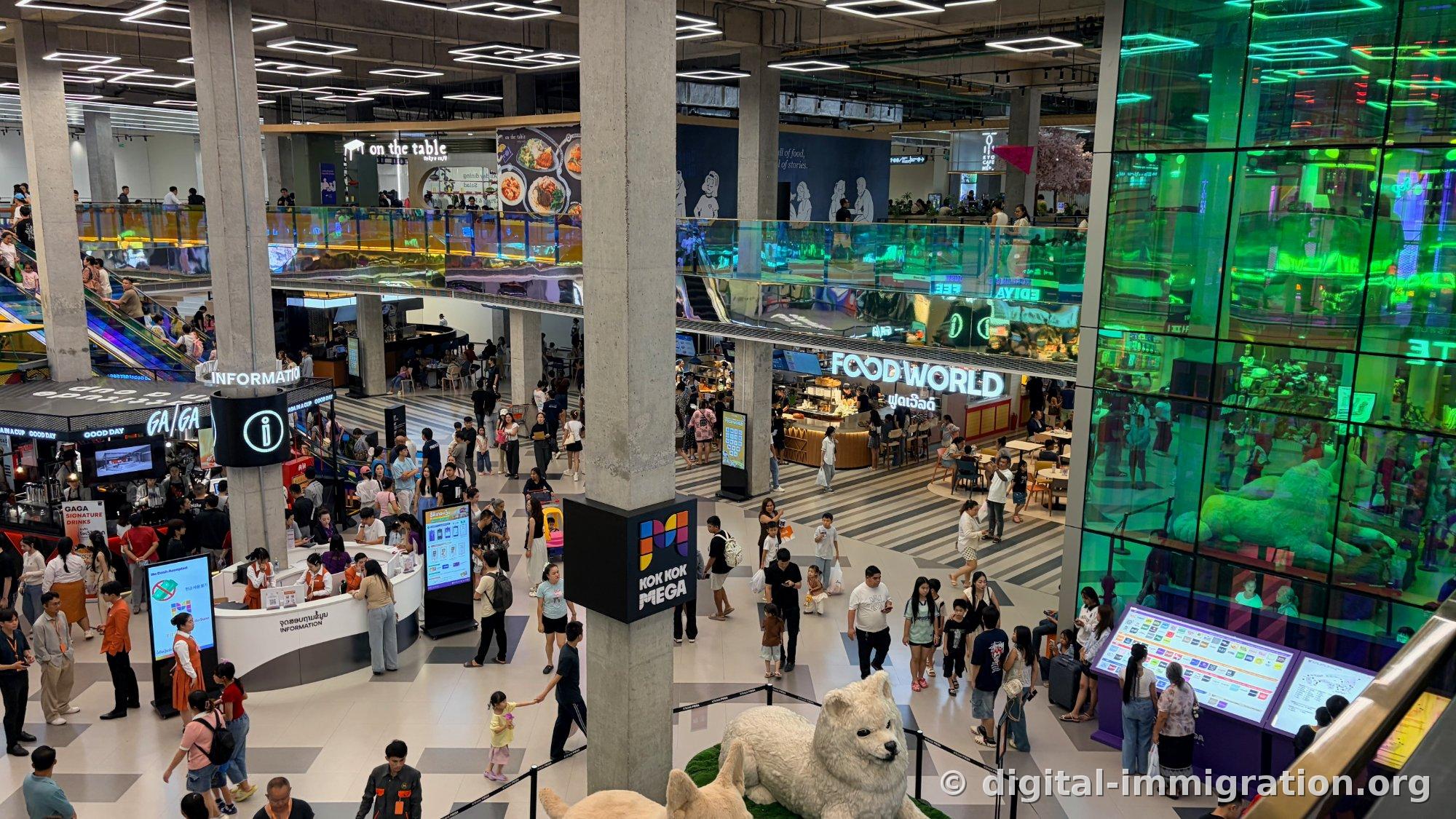 Upper floor view of FOOD WORLD signage and on the table, EDIYA store, white dog sculpture in central hall below