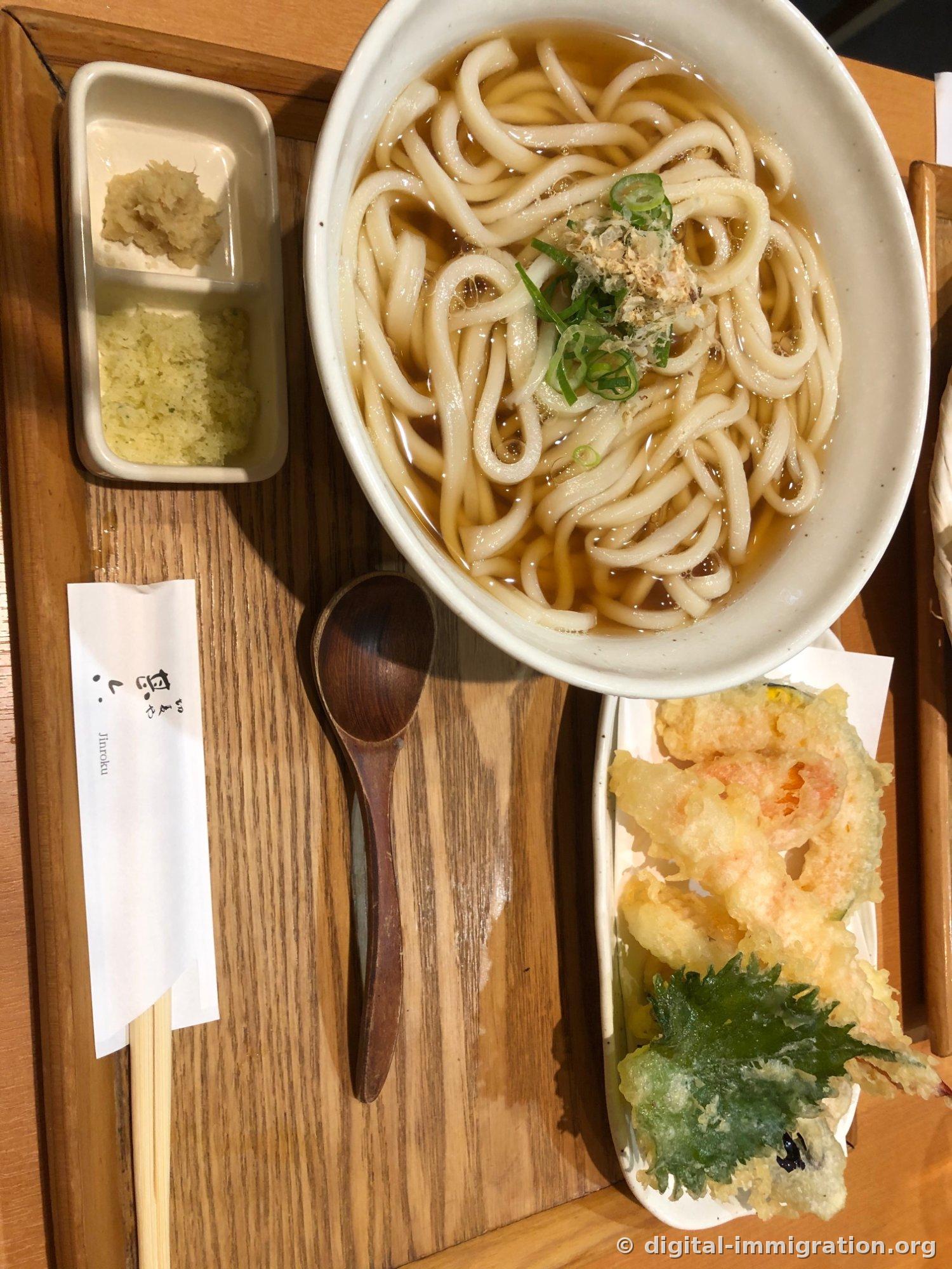 木製のトレーに盛られたてんかけうどん一食、褐色の出汁うどん丼とエビ・野菜揚げ物の皿、生姜と柚子の皮の小鉢、Jinrokuロゴが印刷された箸の袋