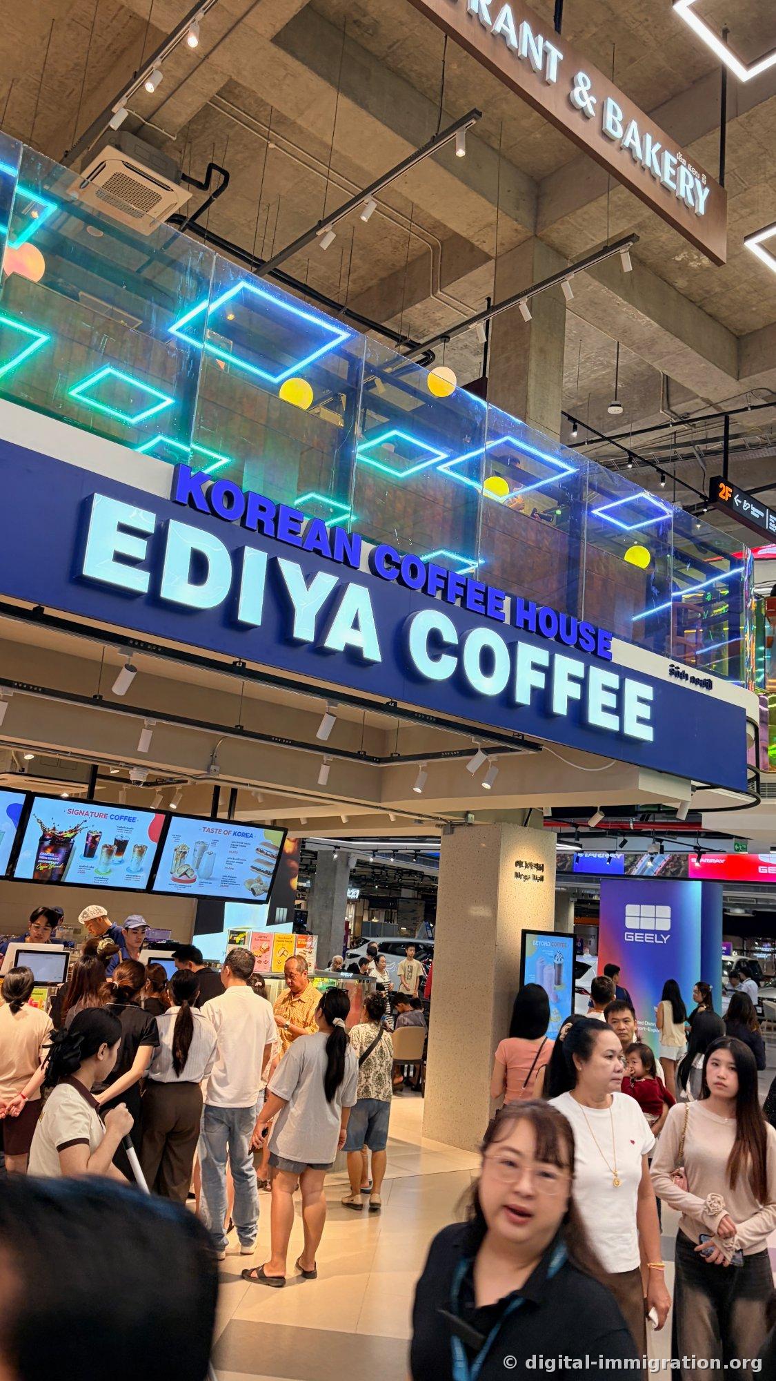 'KOREAN COFFEE HOUSE EDIYA COFFEE' blue signage with customers queuing to order, 'TASTE OF KOREA' displayed on menu monitor