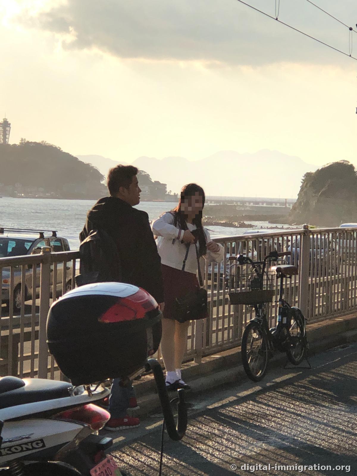 Vu au niveau des yeux de la plage, la Baie de Sagami avec plusieurs couches de vagues blanches arrivant et un surfeur visible au loin