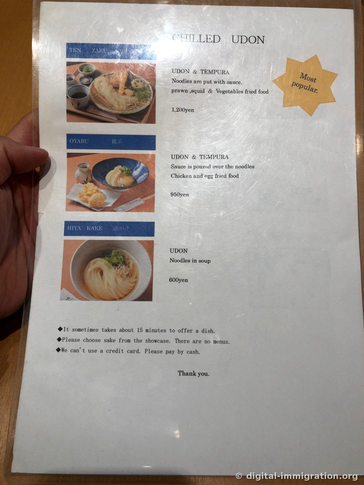 CHILLED UDON英語メニュー板、てんざる・おやぶ・ひやかけの写真と価格、一番下に15分所要・酒は陳列ケースから選択・カード不可案内が書かれている