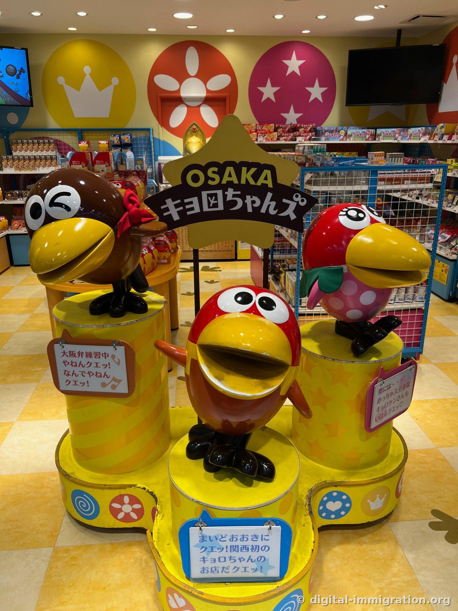 Three Morinaga Kiyorochan character figures in a candy shop, with the 'OSAKA Kiyorochan' sign