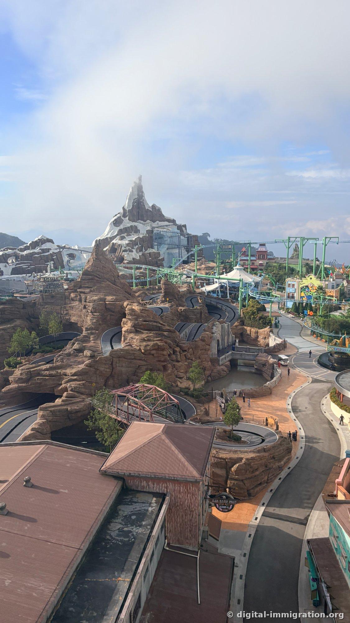 Vertical photo of Genting SkyWorlds central plaza from above with barely any people in the passage and SKYWORLDS logo sculpture
