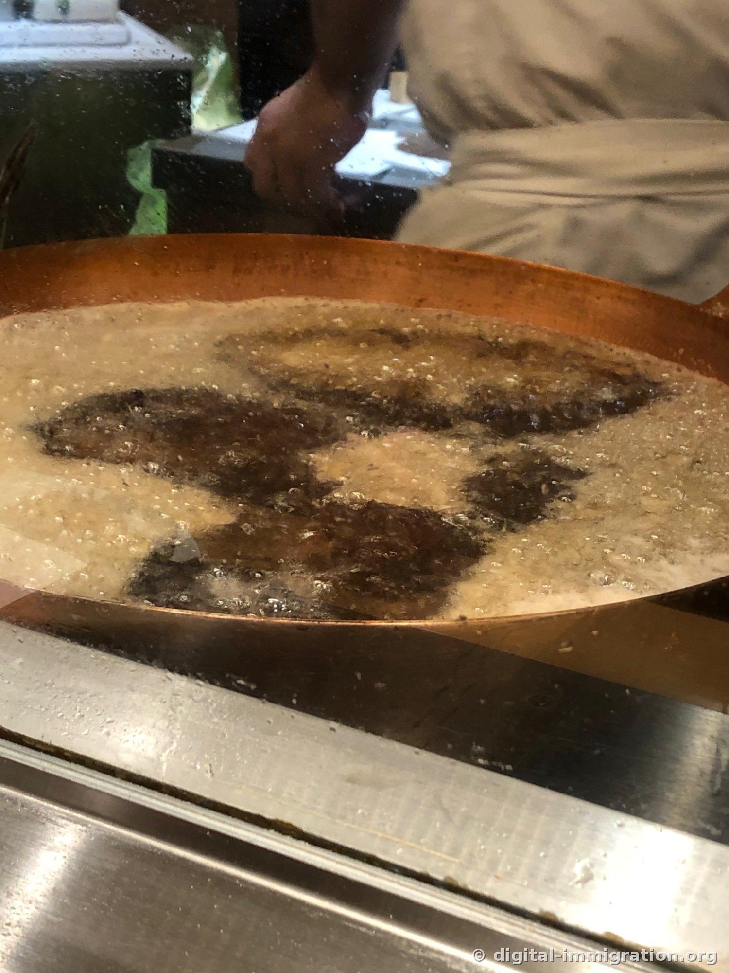 玻璃隔板外的铜炸锅，深色的油里炸猪排的影子在晃动，气泡不断升起