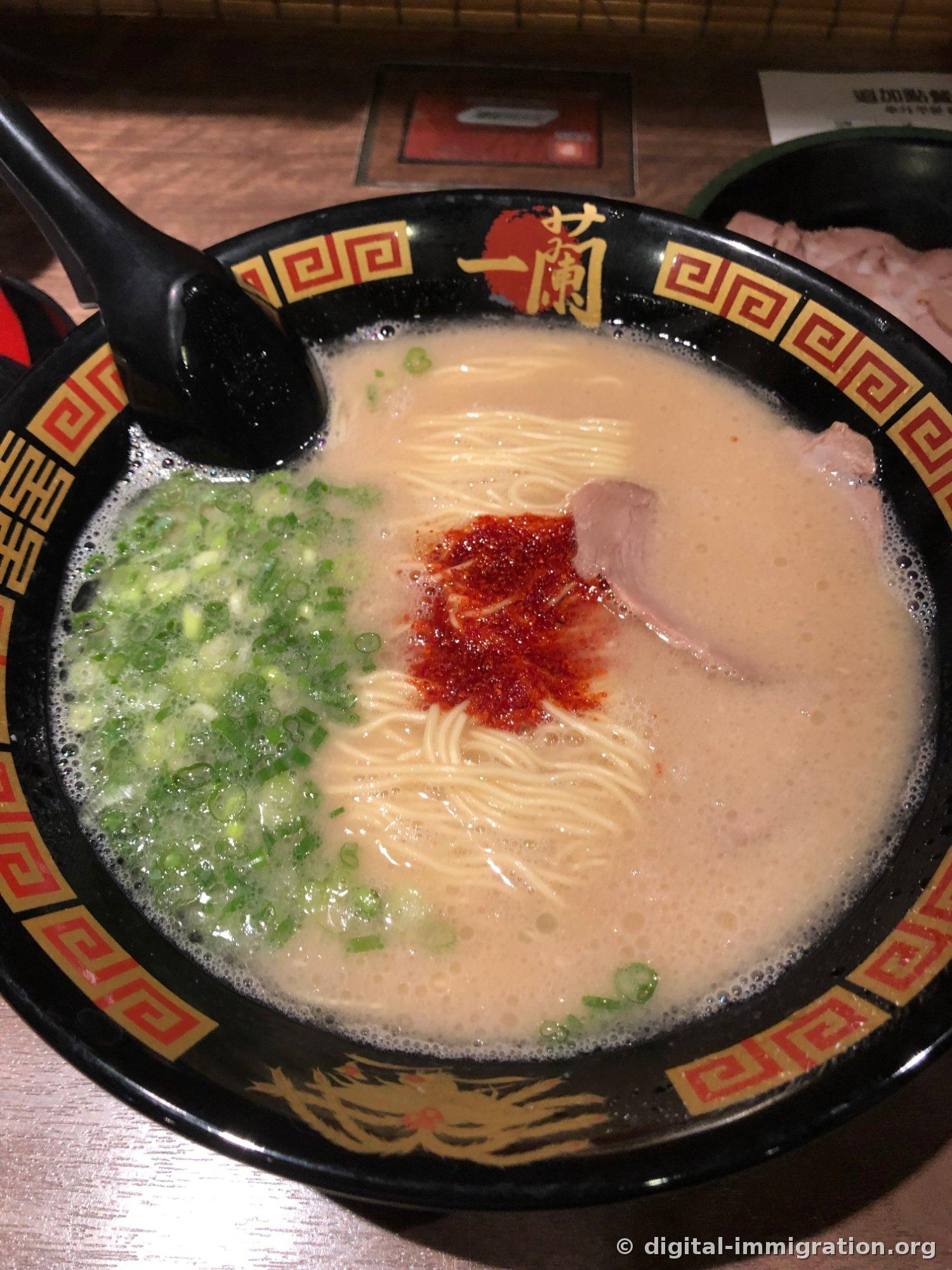 Vue d'en haut du ramen d'Ichiran, avec un contraste entre le bouillon tonkotsu blanc et la sauce spéciale rouge et l'oignon vert