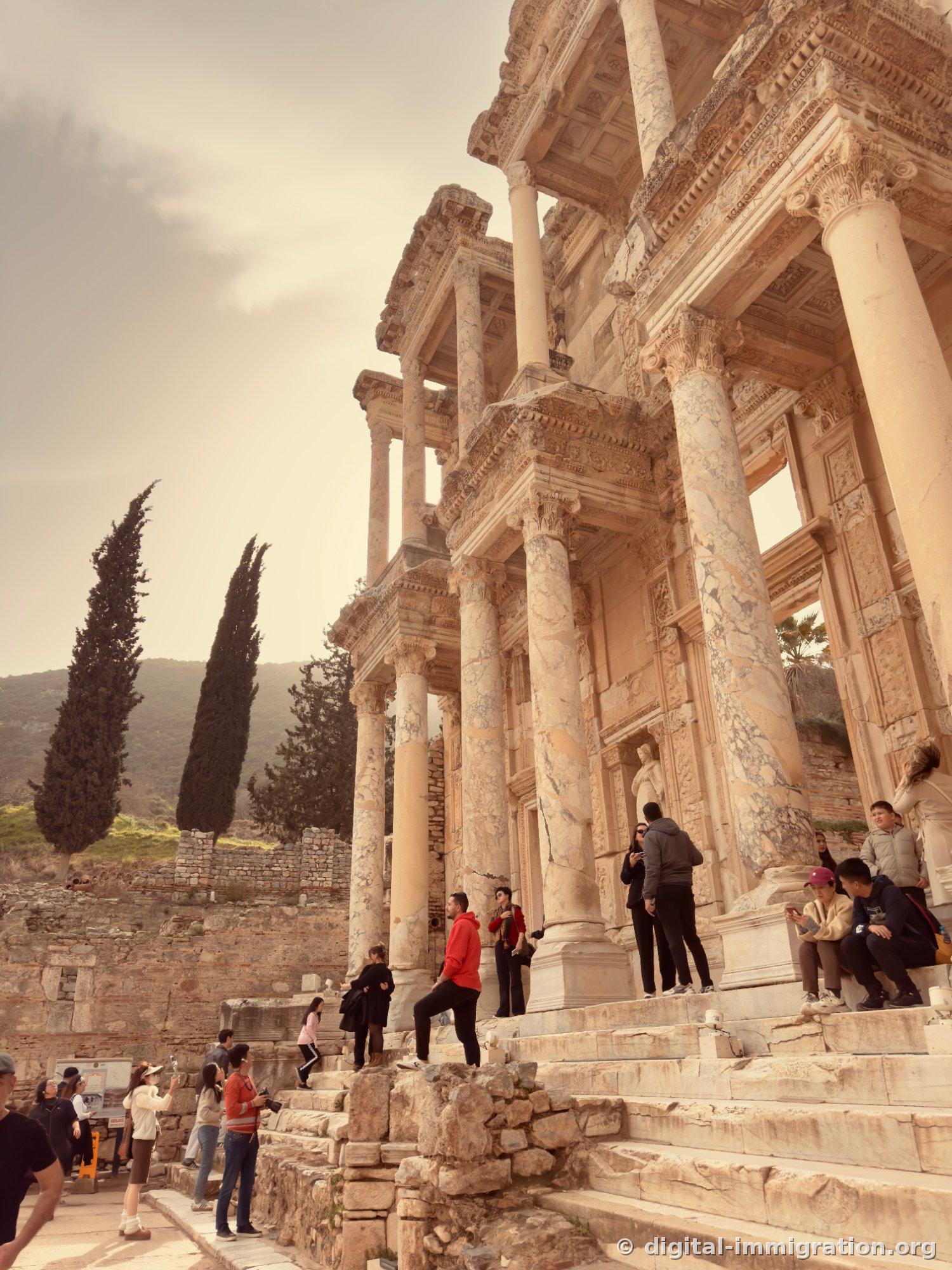 A guide holding a microphone explaining in front of tourists standing next to the marble slab with the serpent relief