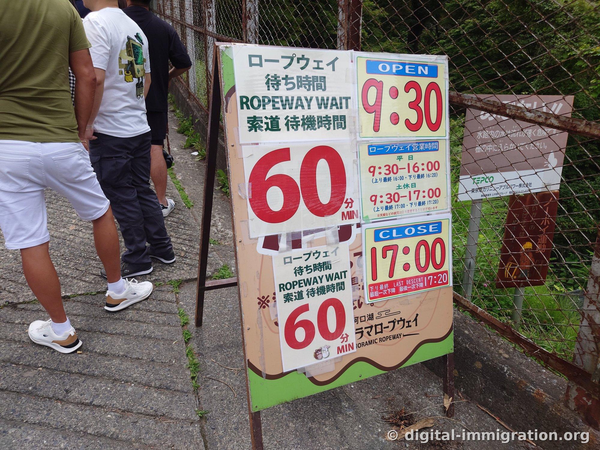 A waiting time sign reading 'ROPEWAY WAIT 60分' and a placard showing weekday hours 9:30-16:00 and weekend/holiday hours 9:30-17:00