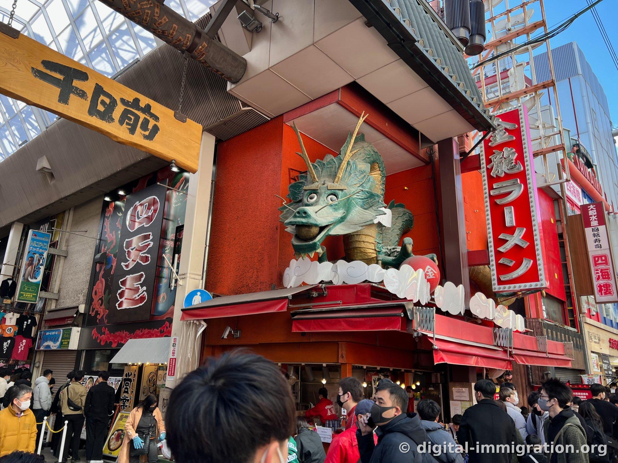 Une énorme statue de dragon vert assis sur le toit du restaurant Kinryu Ramen à côté de l'entrée de l'arcade Senichimae