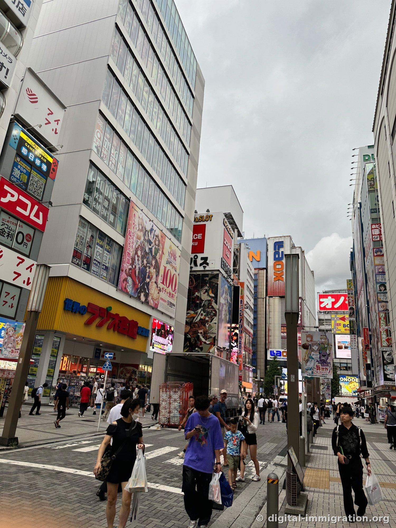 Radio Hall building with yellow sign and glass exterior with K-BOOKS signage, pedestrians walking in front