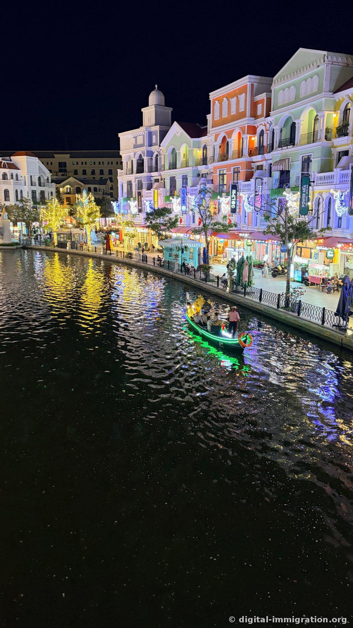 Night canal with a green neon-lit gondola passing by with the boatman, a