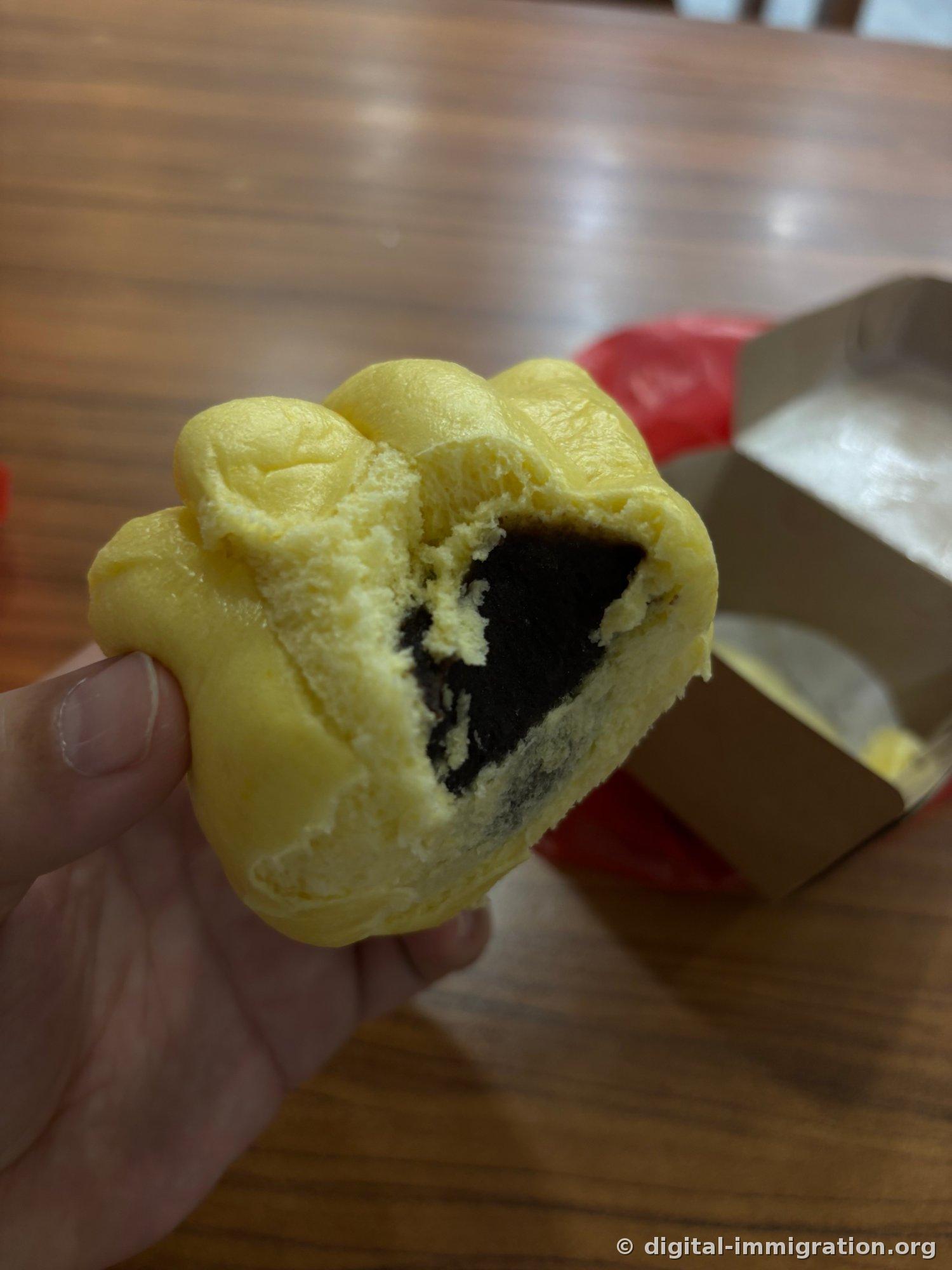 Section transversale du baozi en forme de fleur ouvert à la main. À l'intérieur se trouve une garniture noire finement moulue