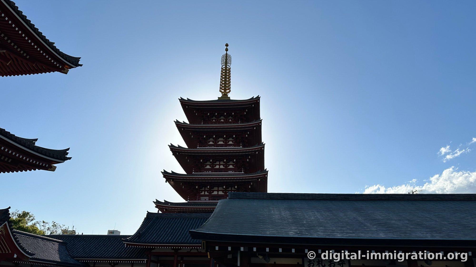 The five-story pagoda as a black silhouette against the sky, with the 'お札お守' booth roof visible below on the right