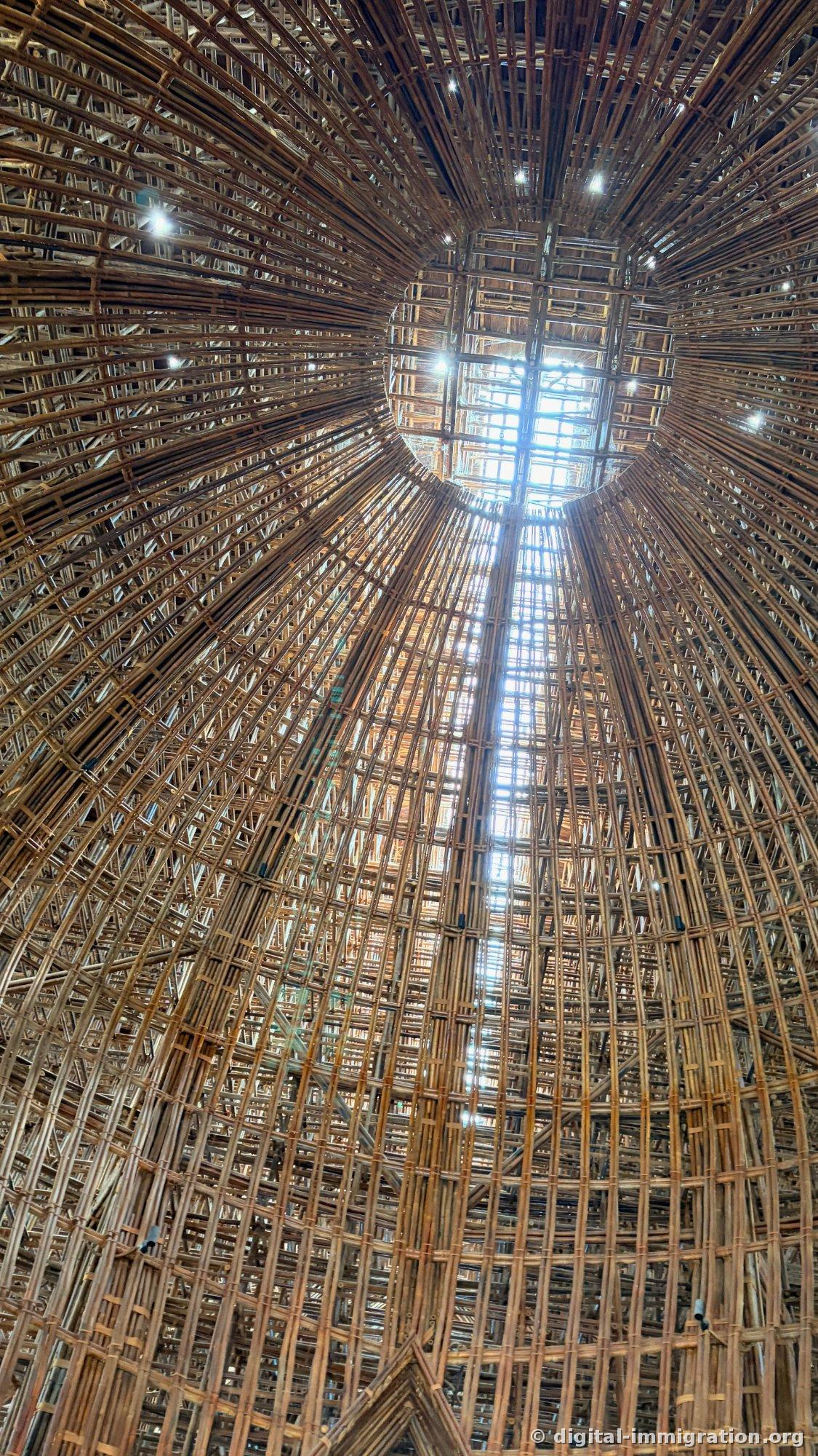 Dome interior ceiling with bamboo strips radiating upward and sunlight coming through a central skylight
